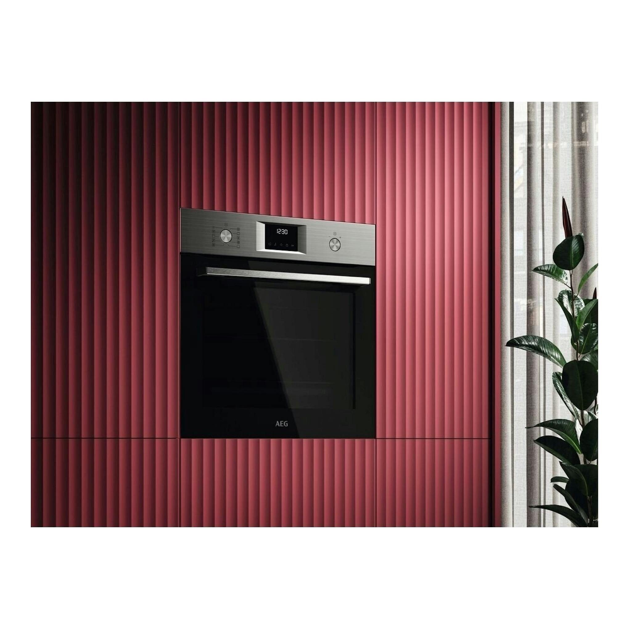 Horno empotrado AEG TU5PB43SM en negro y acero inoxidable, vista frontal, integrado en mueble rosa.