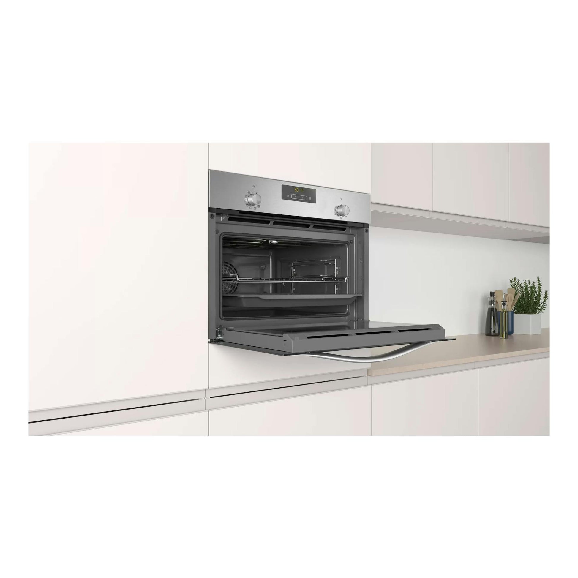 Horno compacto Balay 3CB4130X2 de inox, empotrado y con la puerta abatible abierta en una cocina blanca.