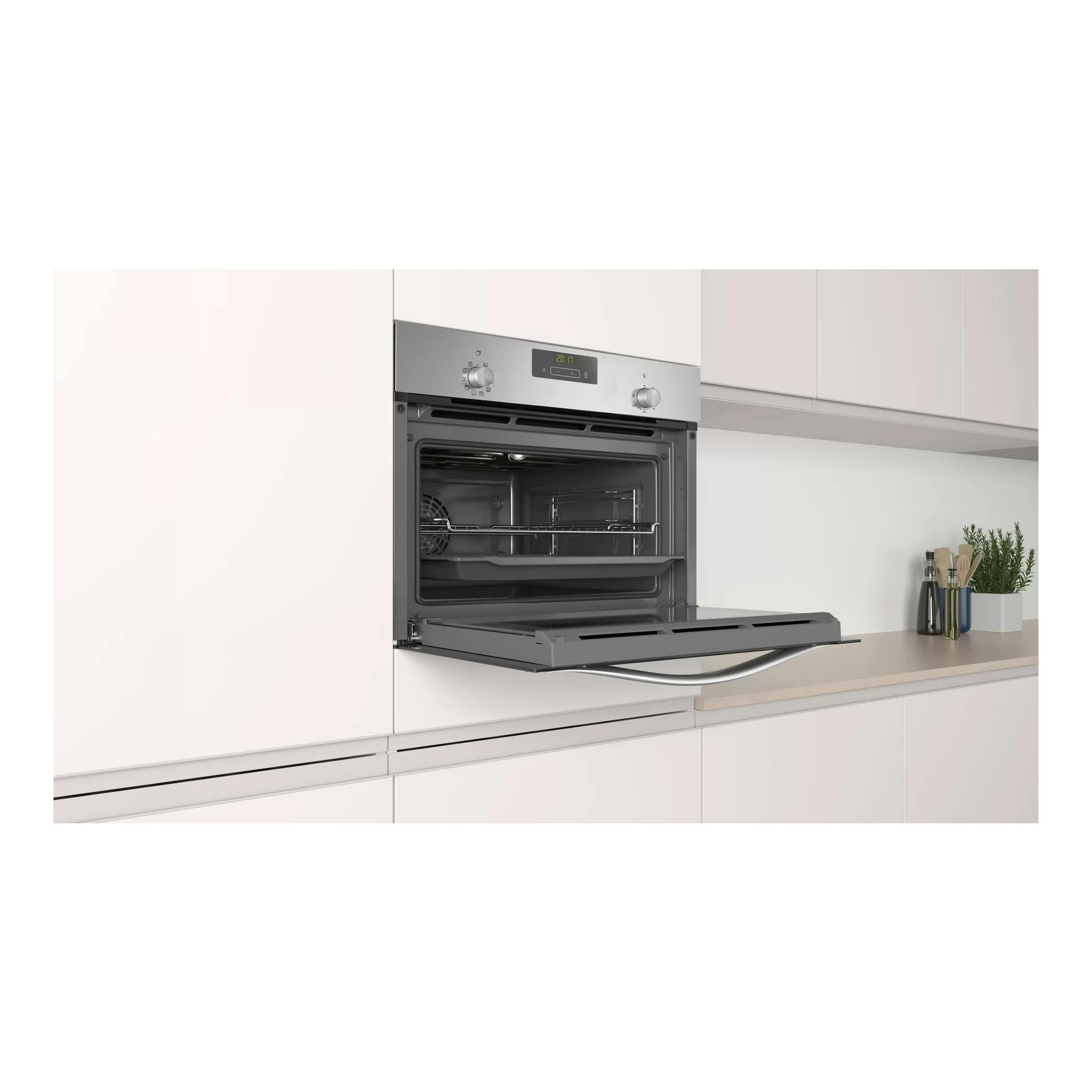 Horno compacto Balay 3CB4130X2 de inox, empotrado y con la puerta abatible abierta en una cocina blanca.