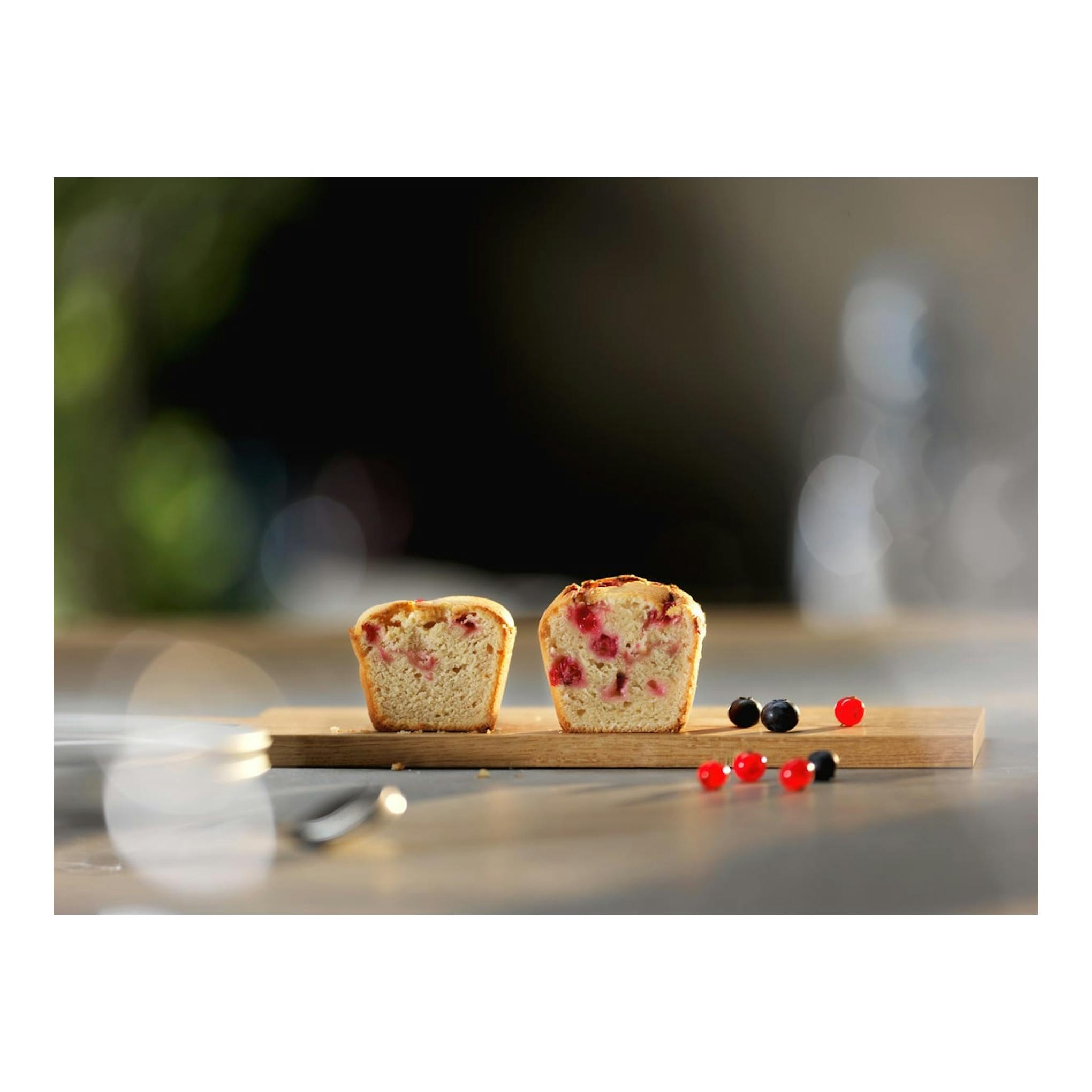 Electrolux EOD6P77X: dos mitades de pan con frutos rojos sobre una tabla de madera, vista frontal.