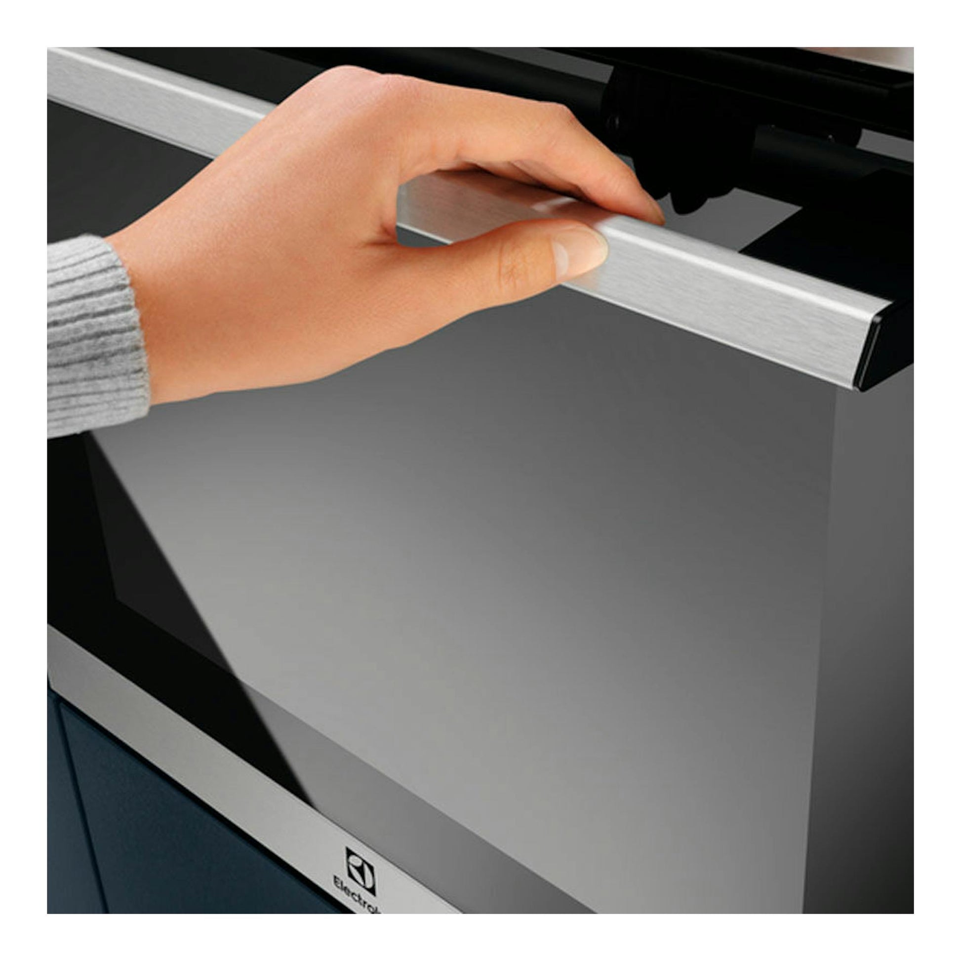 Horno Electrolux EOF3H50BX inox, vista frontal parcial, con una mano abriendo la puerta.