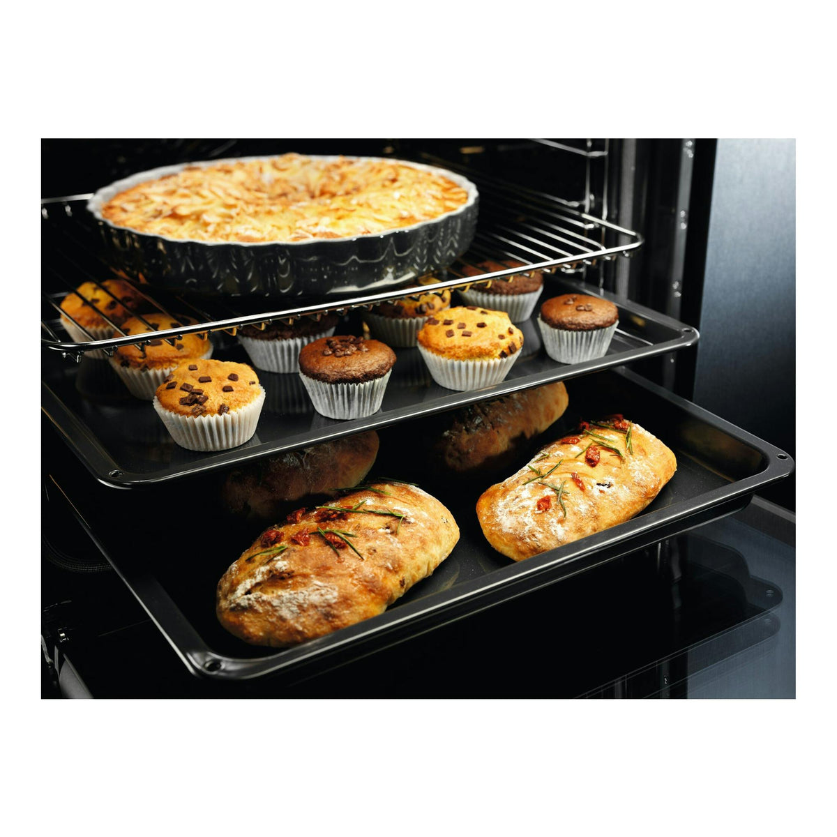 Interior de horno Electrolux EOF4P56X, negro, con varias bandejas y alimentos horneándose.