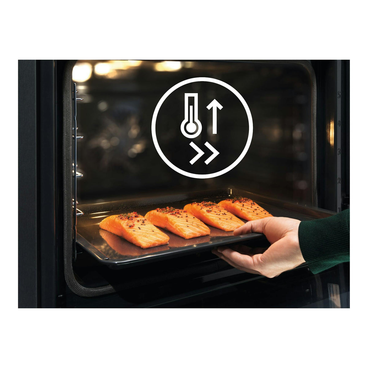 Vista interior frontal de horno Electrolux EOH4P46BX en inox, con bandeja y filetes de salmón; una mano la introduce.