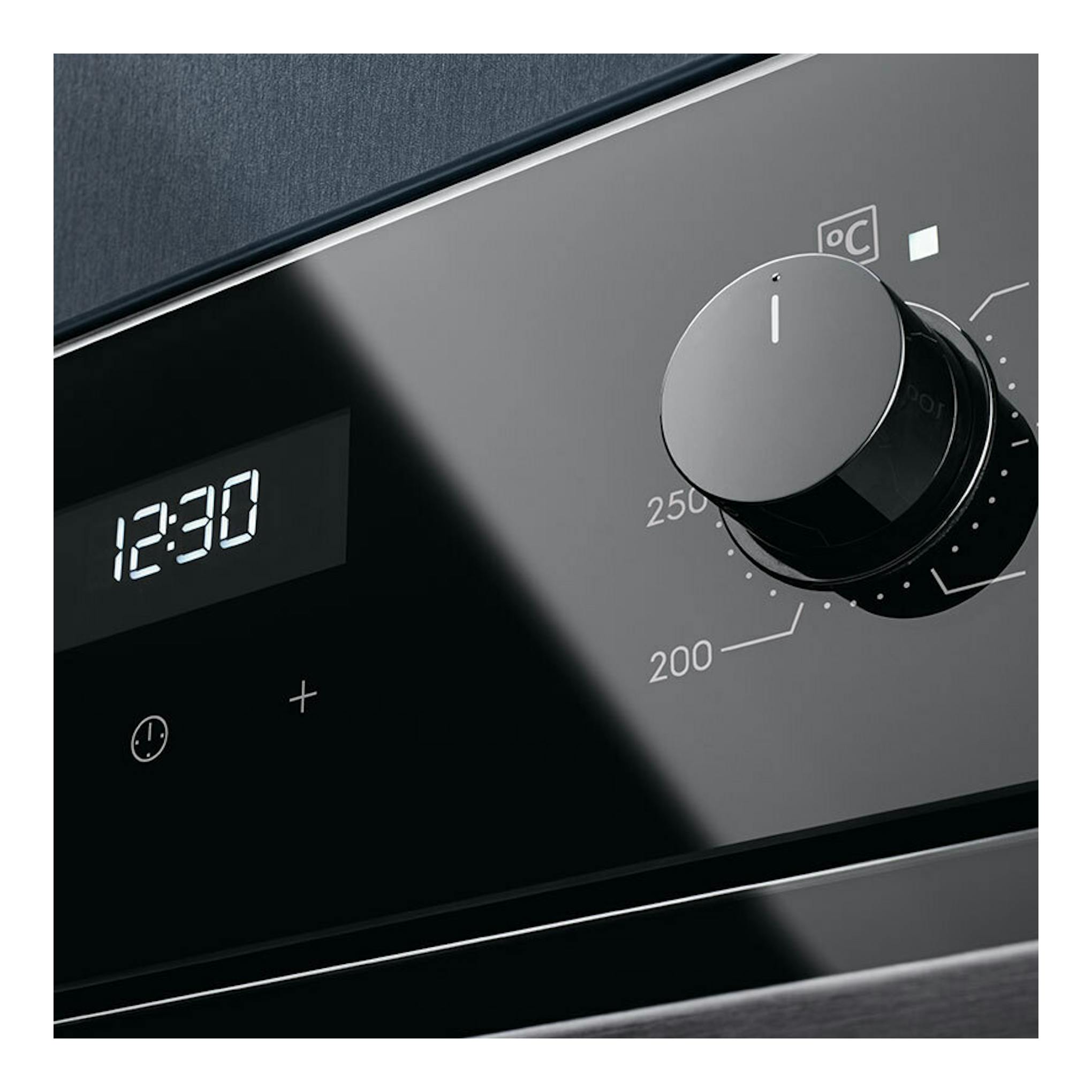 Primer plano del panel frontal de un horno Electrolux OEF5H50BK blanco, con display 12:30 y mando de temperatura negro.