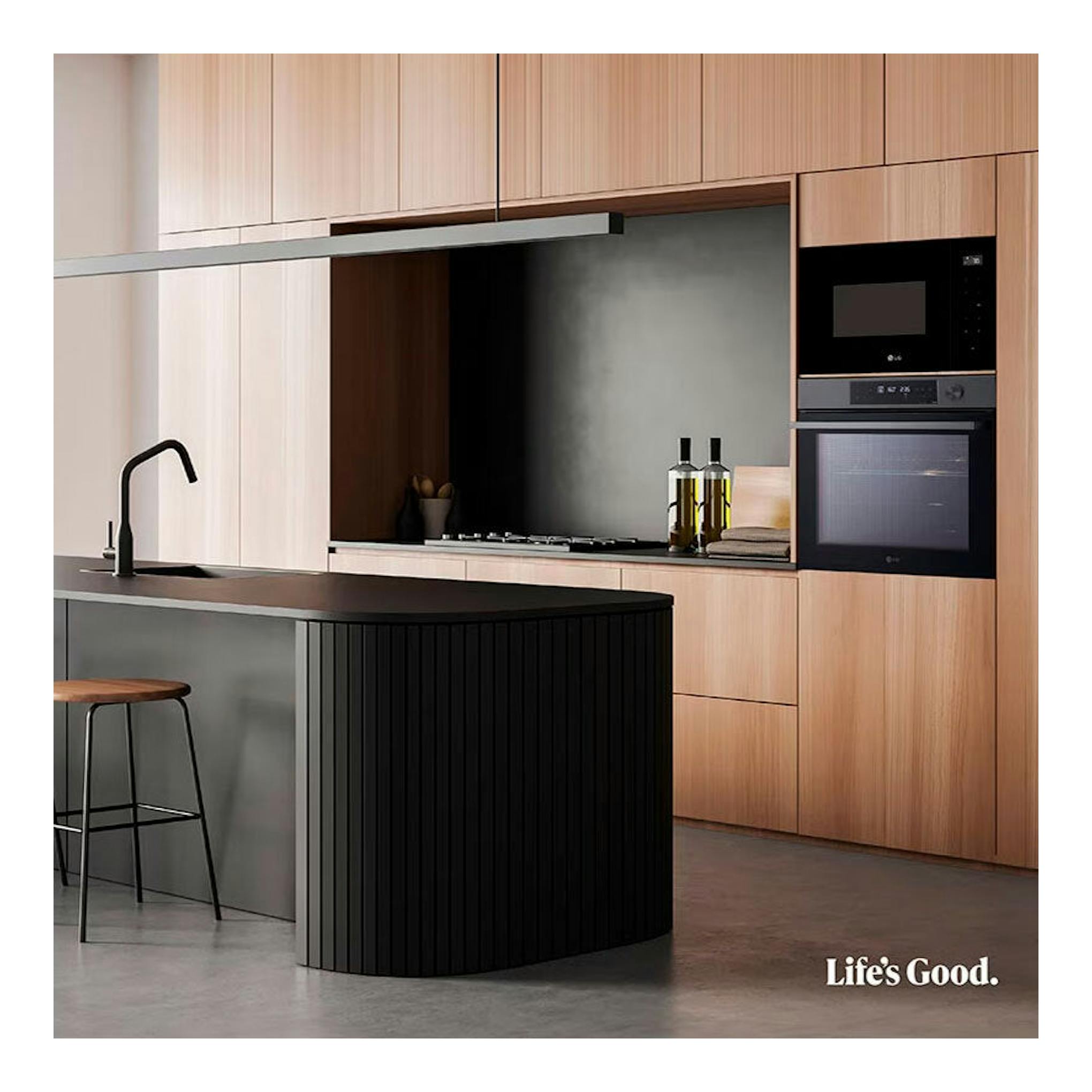 Horno LG WSED7612B negro empotrado, vista frontal, en cocina moderna con muebles de madera.
