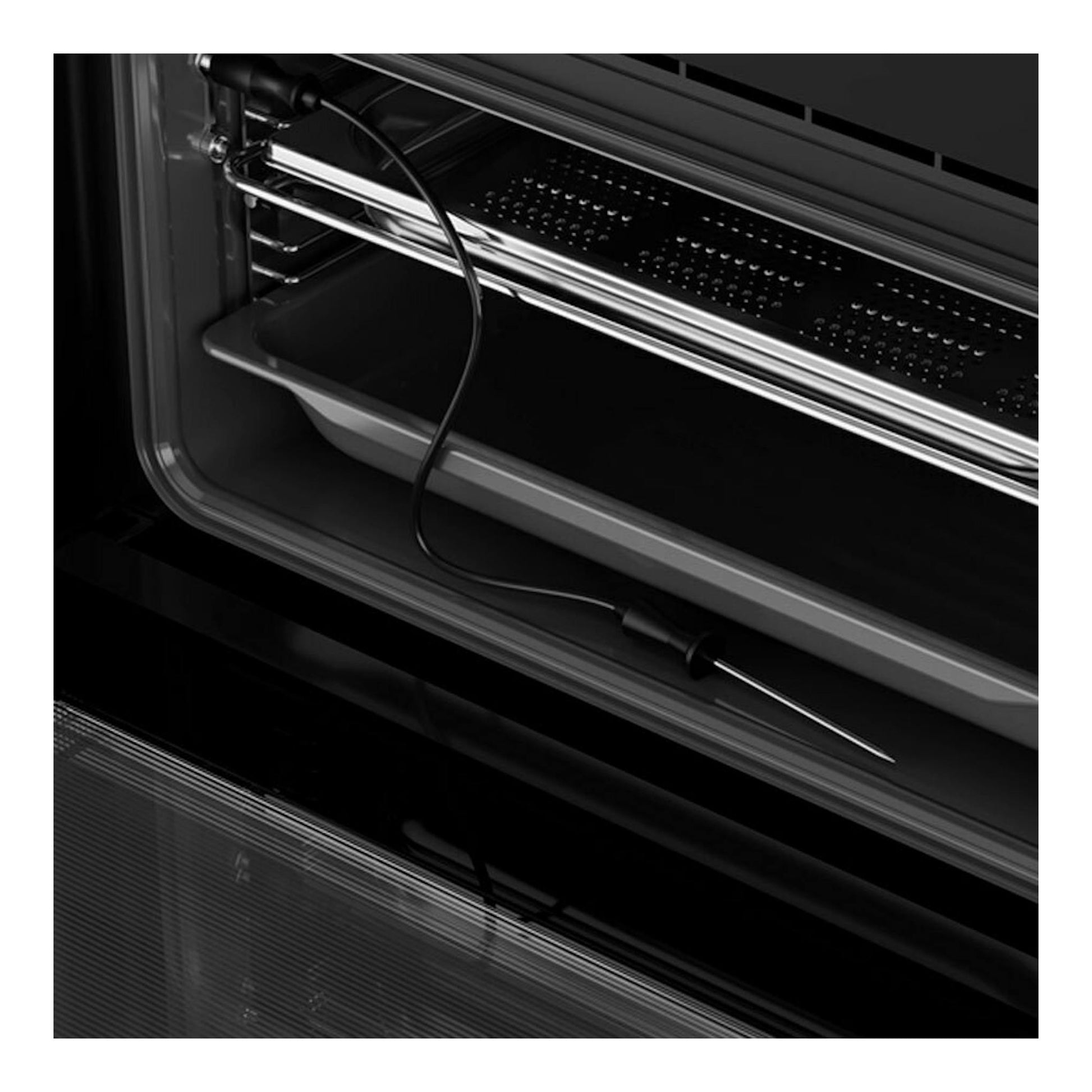Horno Teka HLC8470SC de cristal negro, vista interior en ángulo con sonda de temperatura y bandeja.