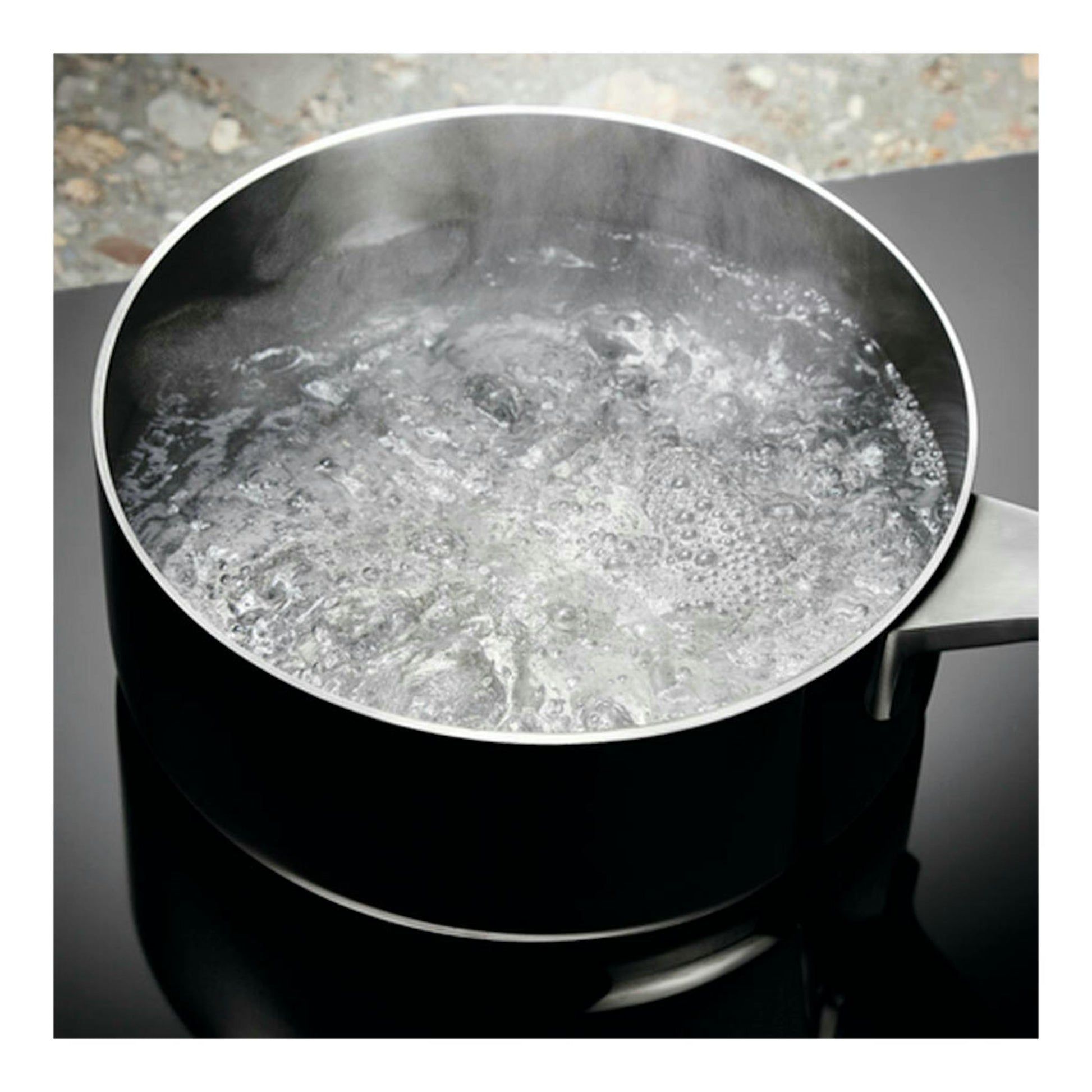 Electrolux EIV95550: vista cenital de una olla de acero sobre placa de inducción negra con agua hirviendo.