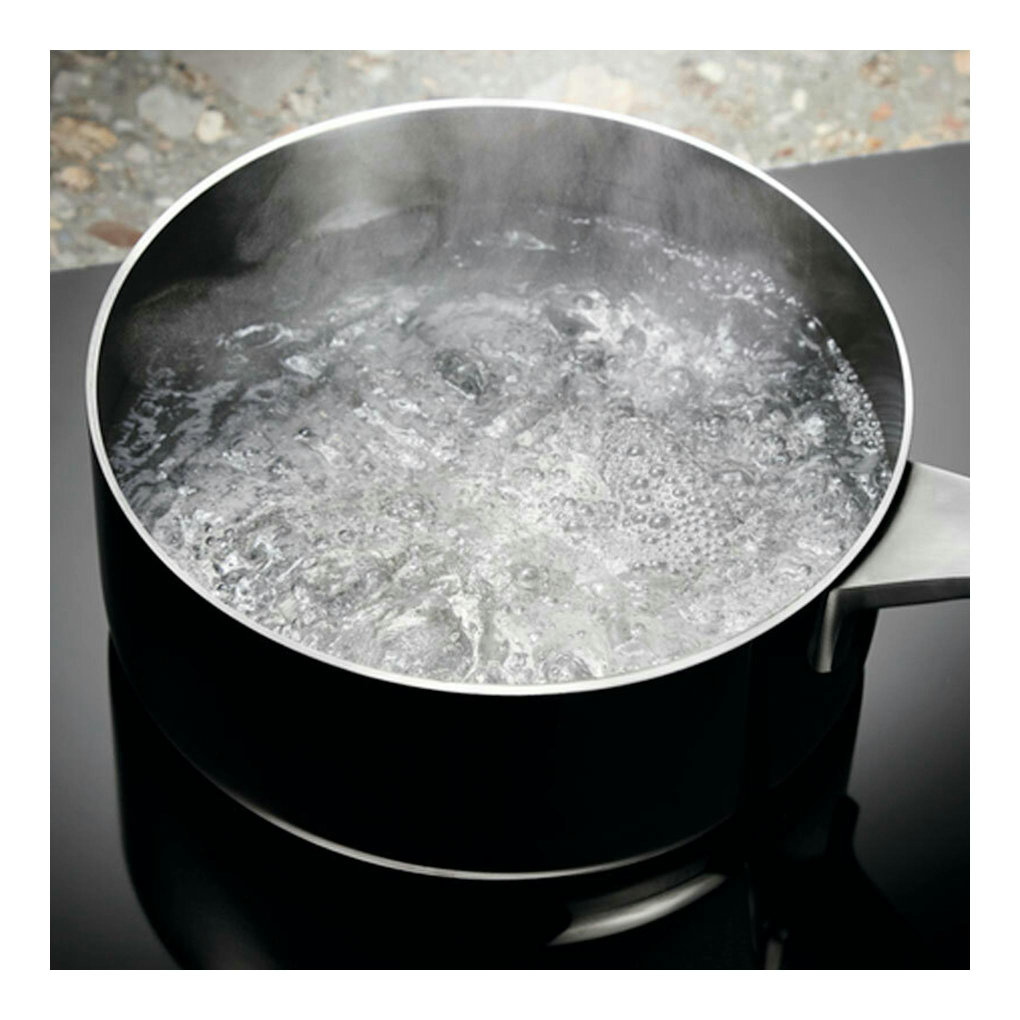 Electrolux EIV95550: vista cenital de una olla de acero sobre placa de inducción negra con agua hirviendo.