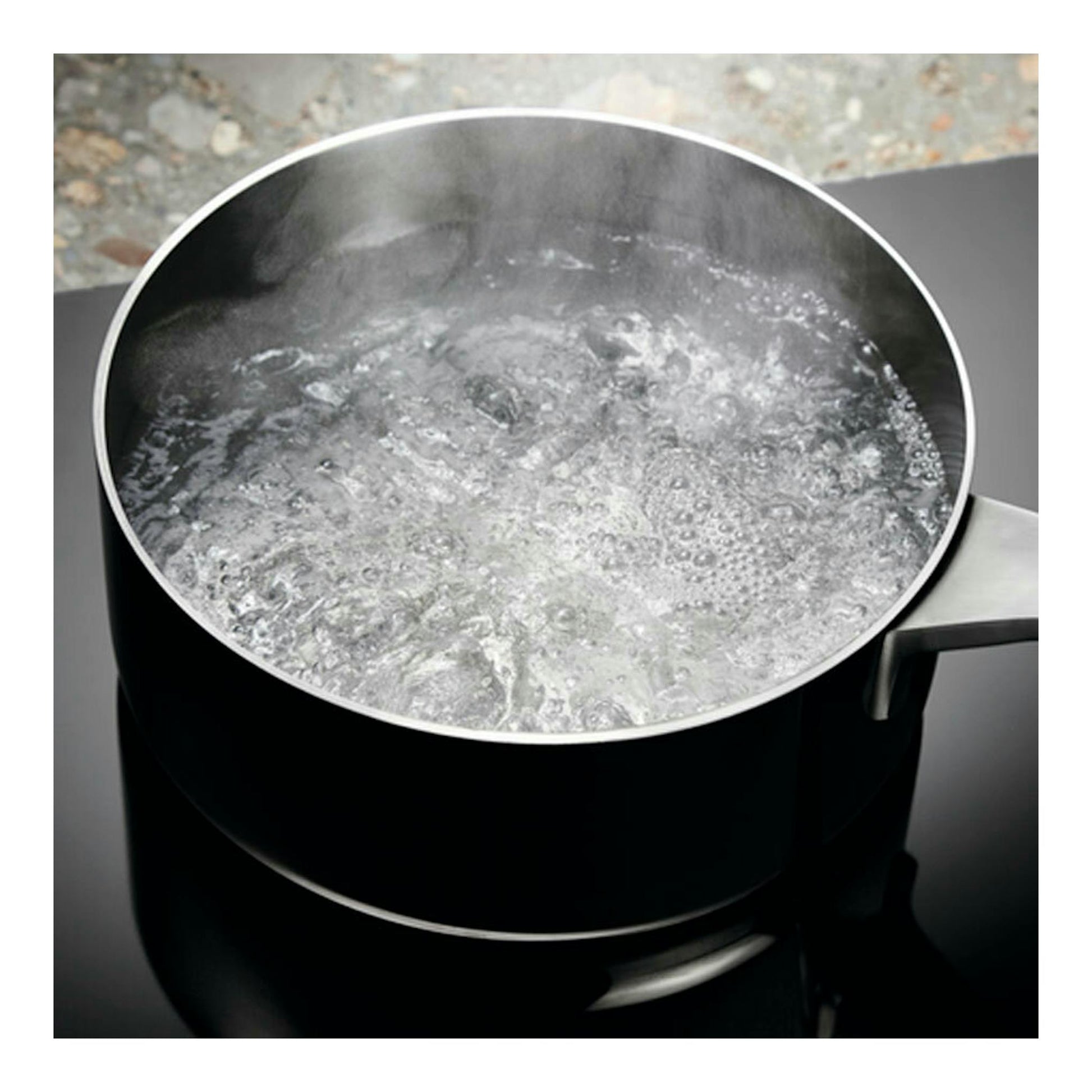 Placa de inducción Electrolux LIT6340CK negra con una olla de agua hirviendo, vista cenital parcial.