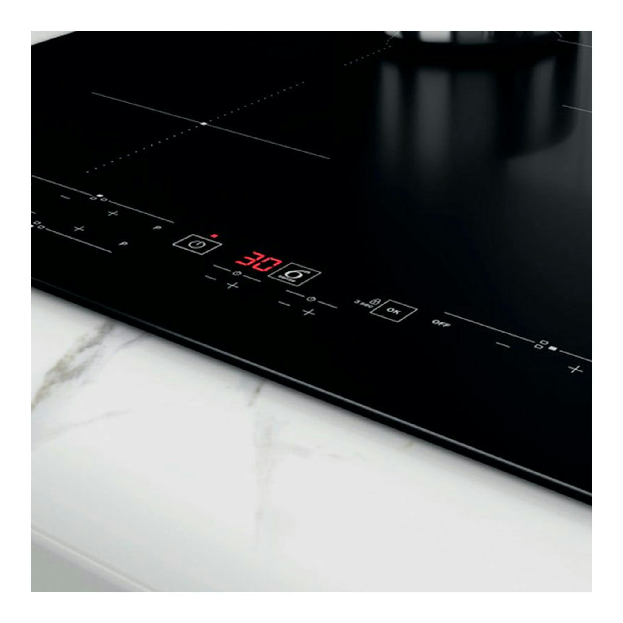 Placa de inducción Whirlpool WSB4760NE negra, vista en ángulo con panel táctil y display rojo.