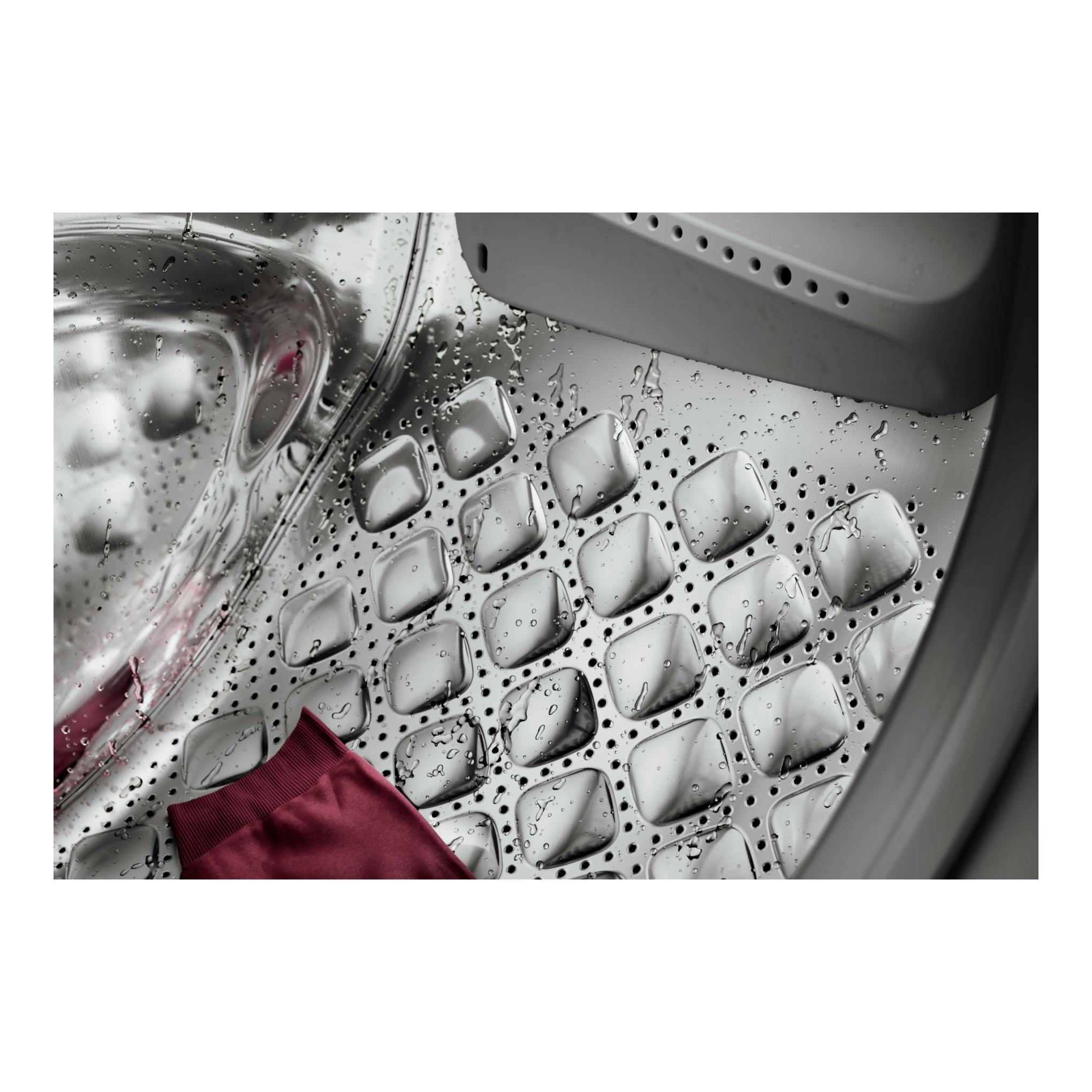 Interior de lavadora AEG LFR7394O4V, vista cenital del tambor de acero con gotas de agua y una prenda rosa.