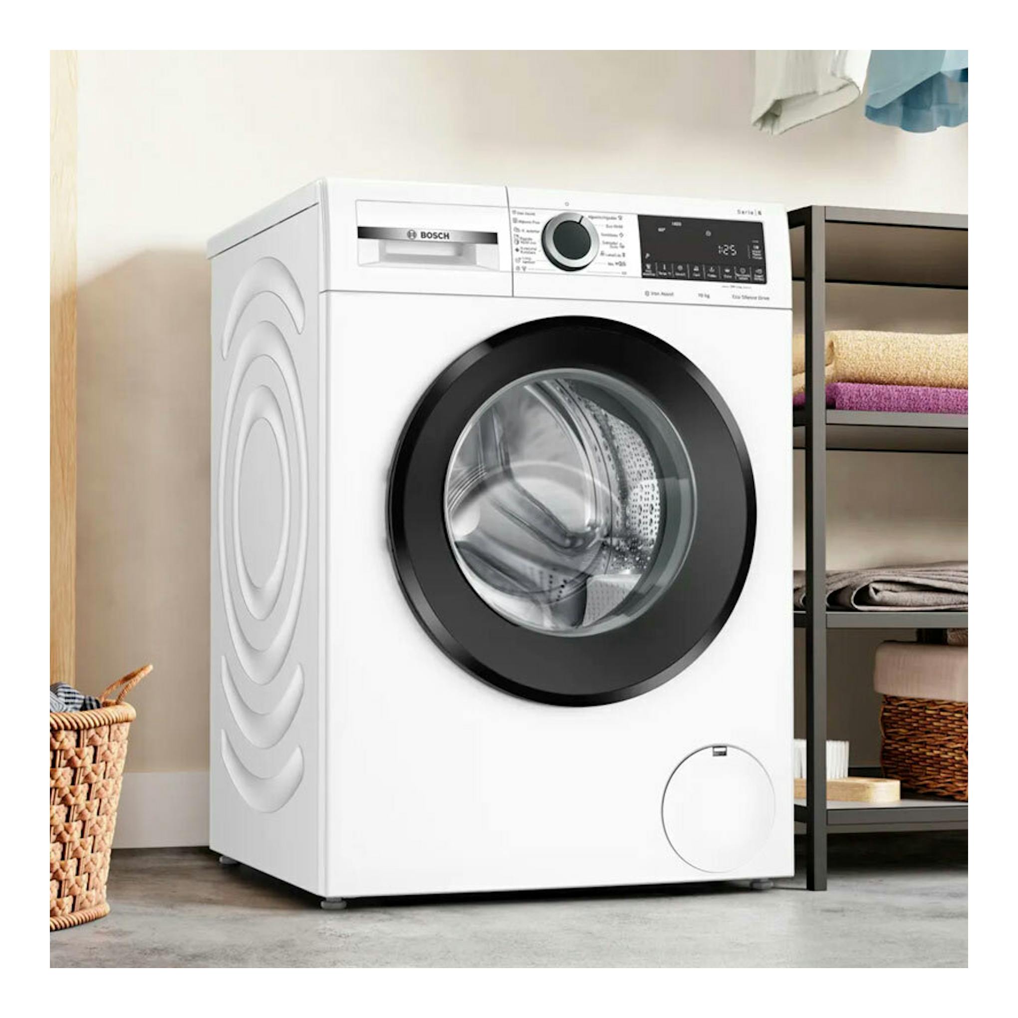 Lavadora Bosch WGG254Z5ES blanca, frontal con puerta negra, vista en ángulo en un cuarto de lavandería.