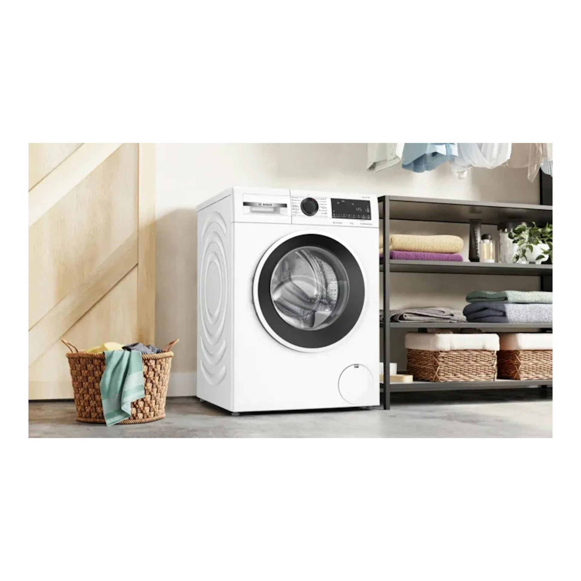 Lavadora Bosch WGG254ZBES blanca, vista frontal, junto a una estantería y una cesta de ropa.
