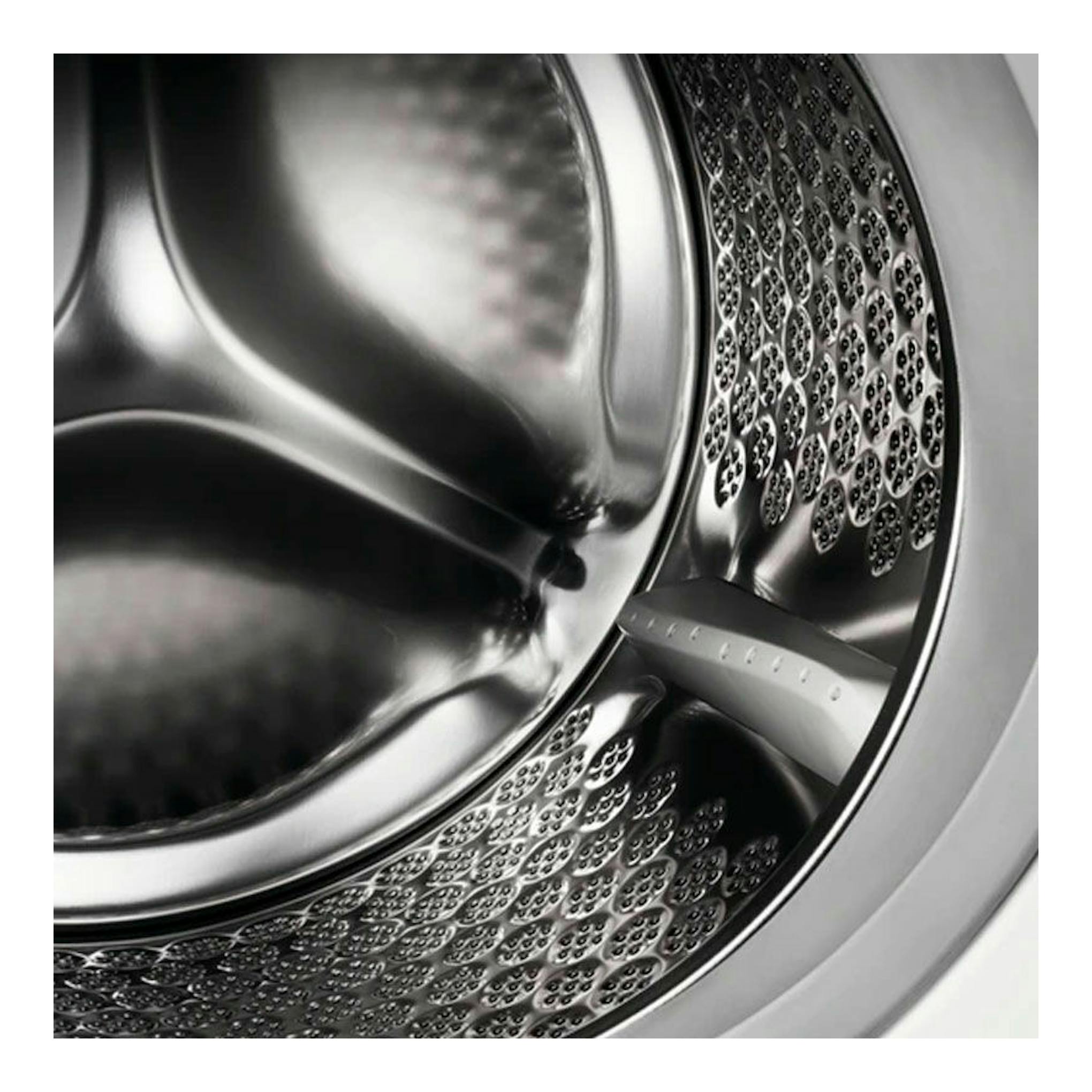 Interior del tambor de una lavadora integrable Electrolux EN7F4722AN, vista cercana en acero inoxidable.