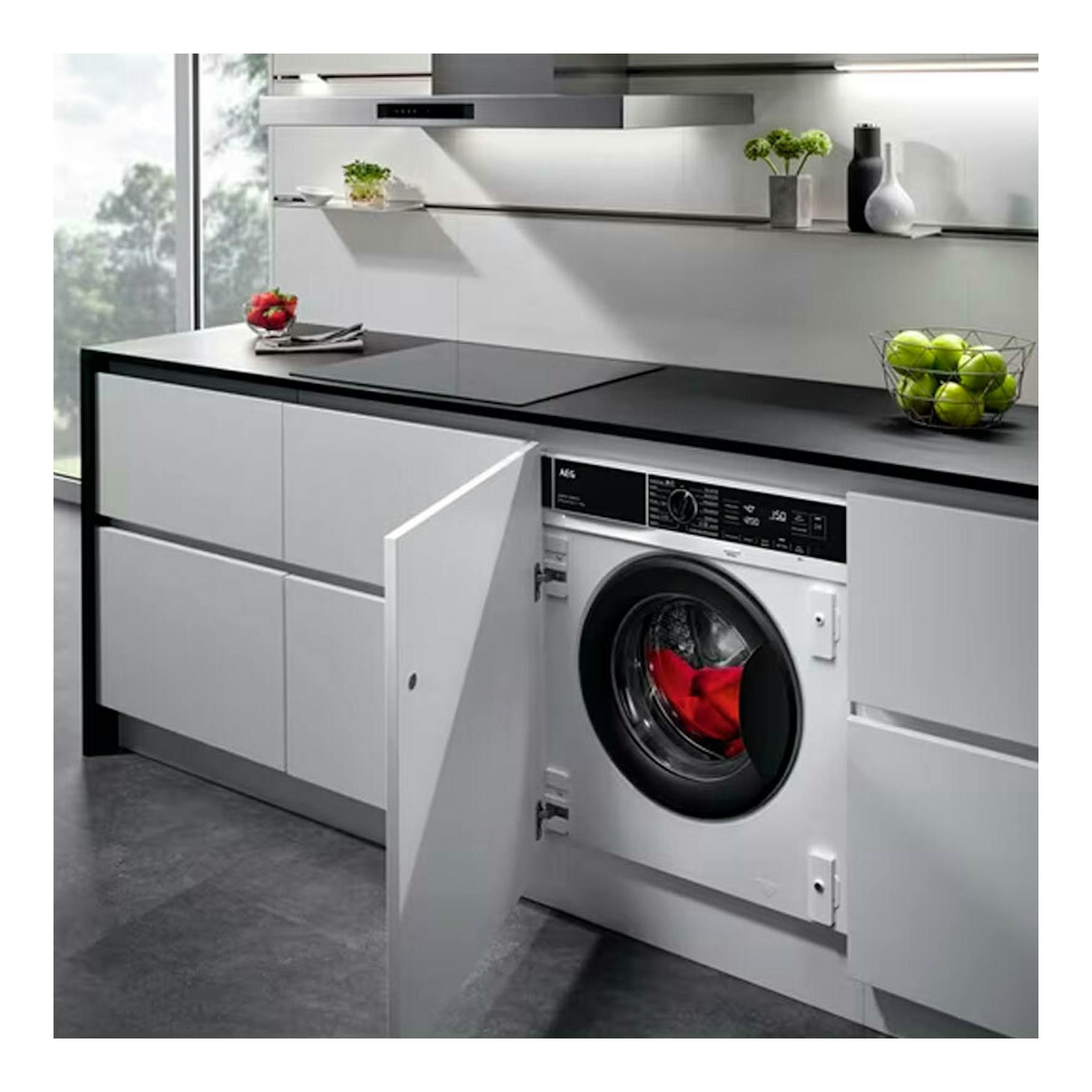 Lavasecadora integrable AEG LWN7E8636F blanca, vista frontal empotrada bajo encimera con puerta abierta.