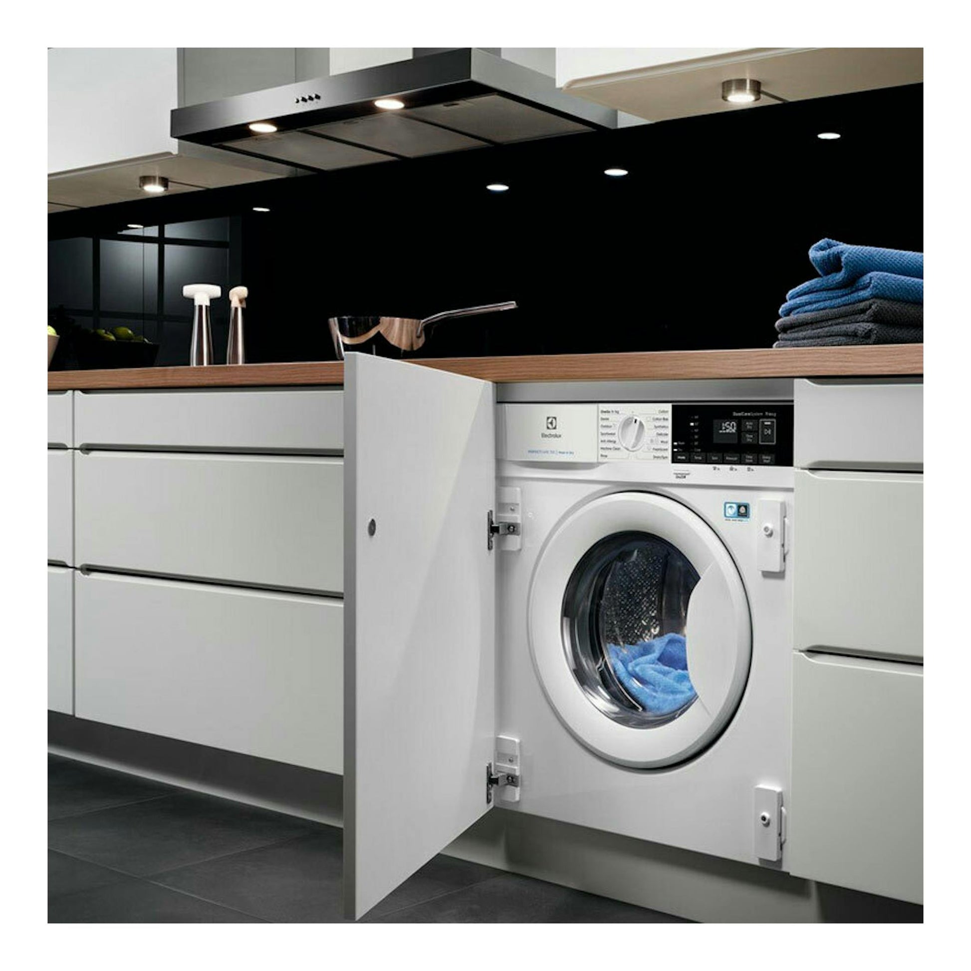 Lavasecadora integrable Electrolux EN7W4862OF blanca, vista frontal, con puerta abierta bajo encimera en cocina.