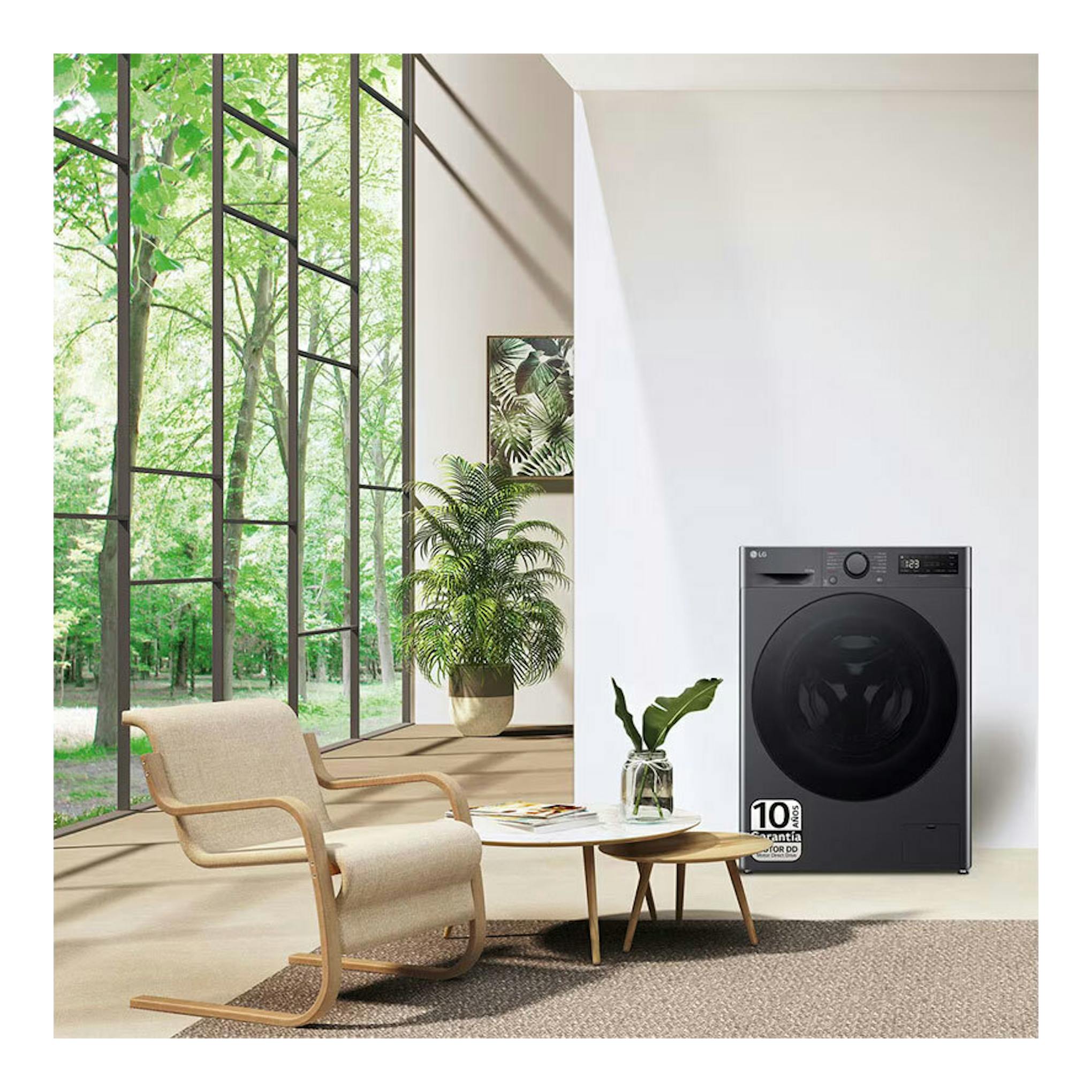 Lavasecadora LG F4DR6010AGM negra, vista frontal, colocada en una sala luminosa junto a una ventana.