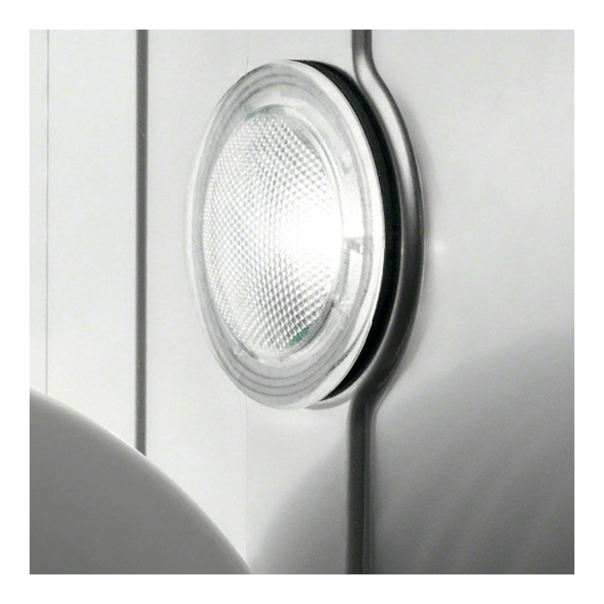 Primer plano del interior de un lavavajillas blanco, con luz circular y panel metálico.