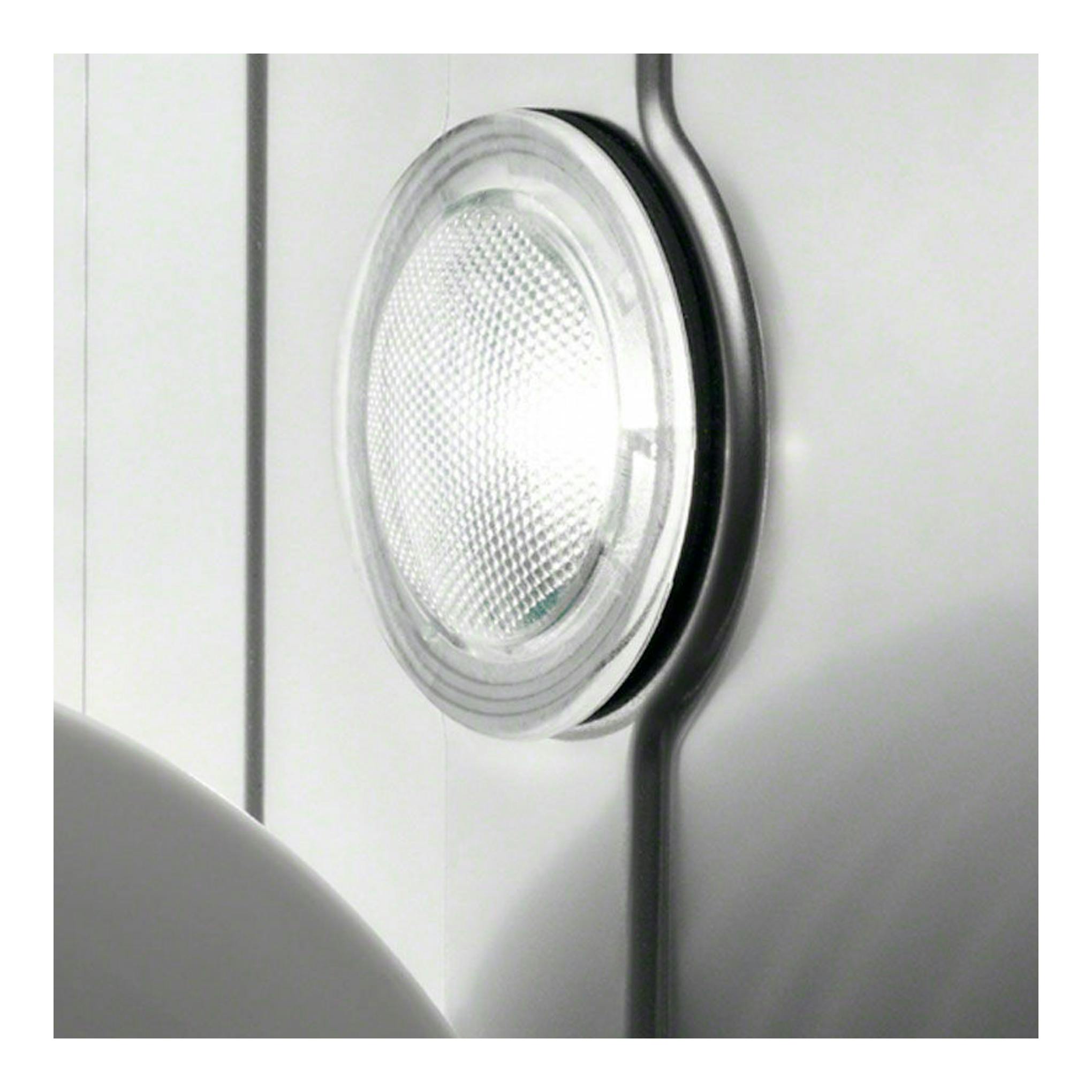 Primer plano del interior de un lavavajillas blanco, con luz circular y panel metálico.