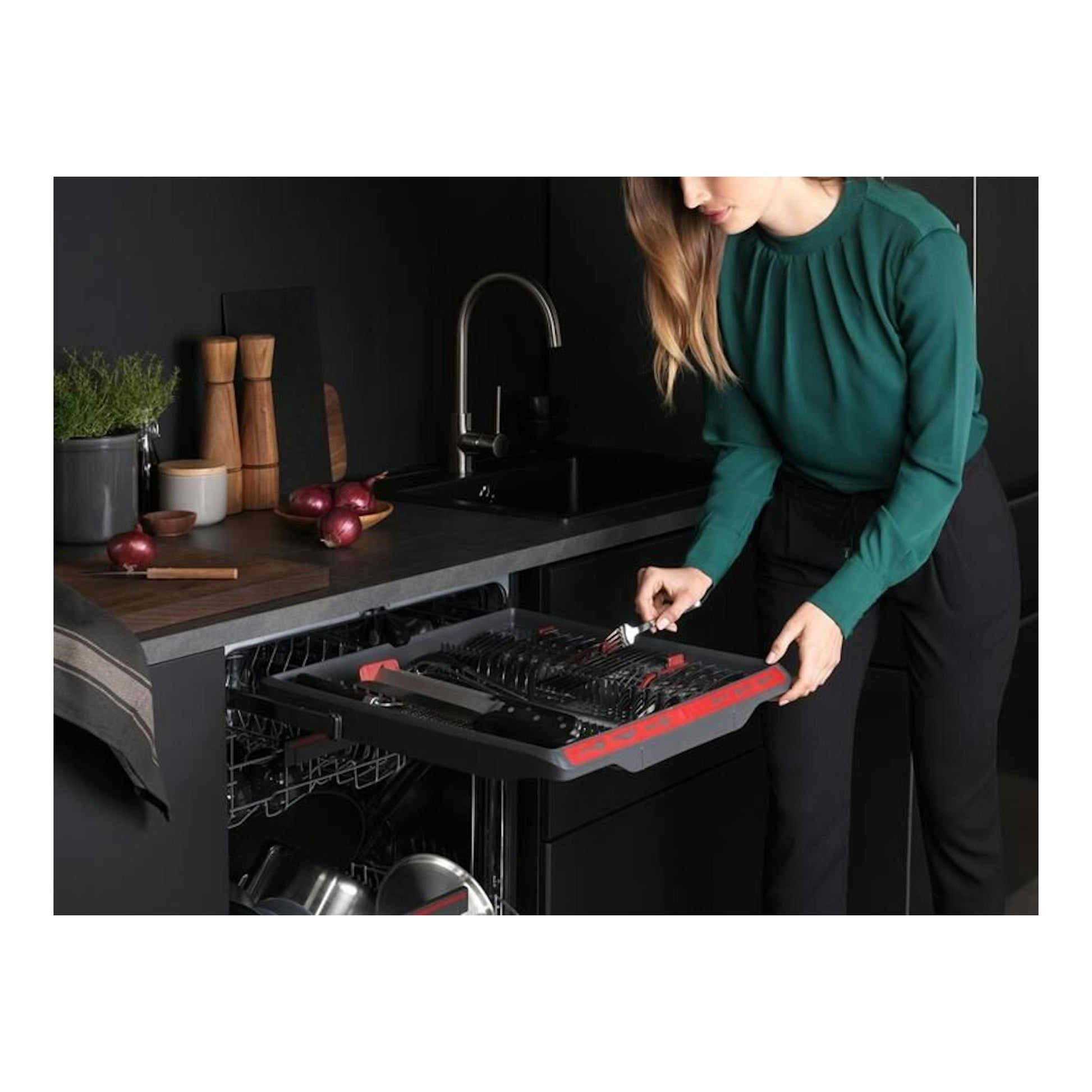 Lavavajillas AEG FSE74707P negro empotrado, abierto, con una mujer colocando cubiertos en una cocina moderna.