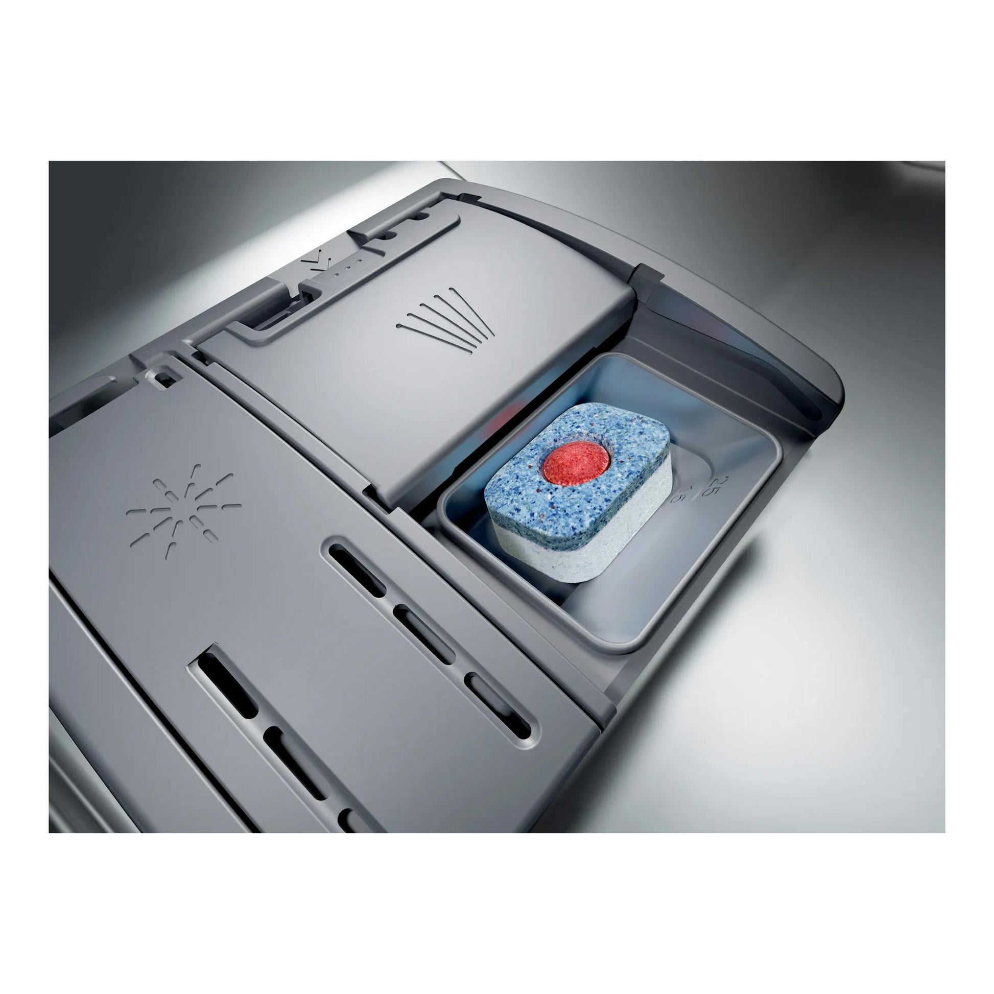 Primer plano del compartimento de detergente de un lavavajillas Bosch SBV6YCX02E, en gris, con pastilla dentro.