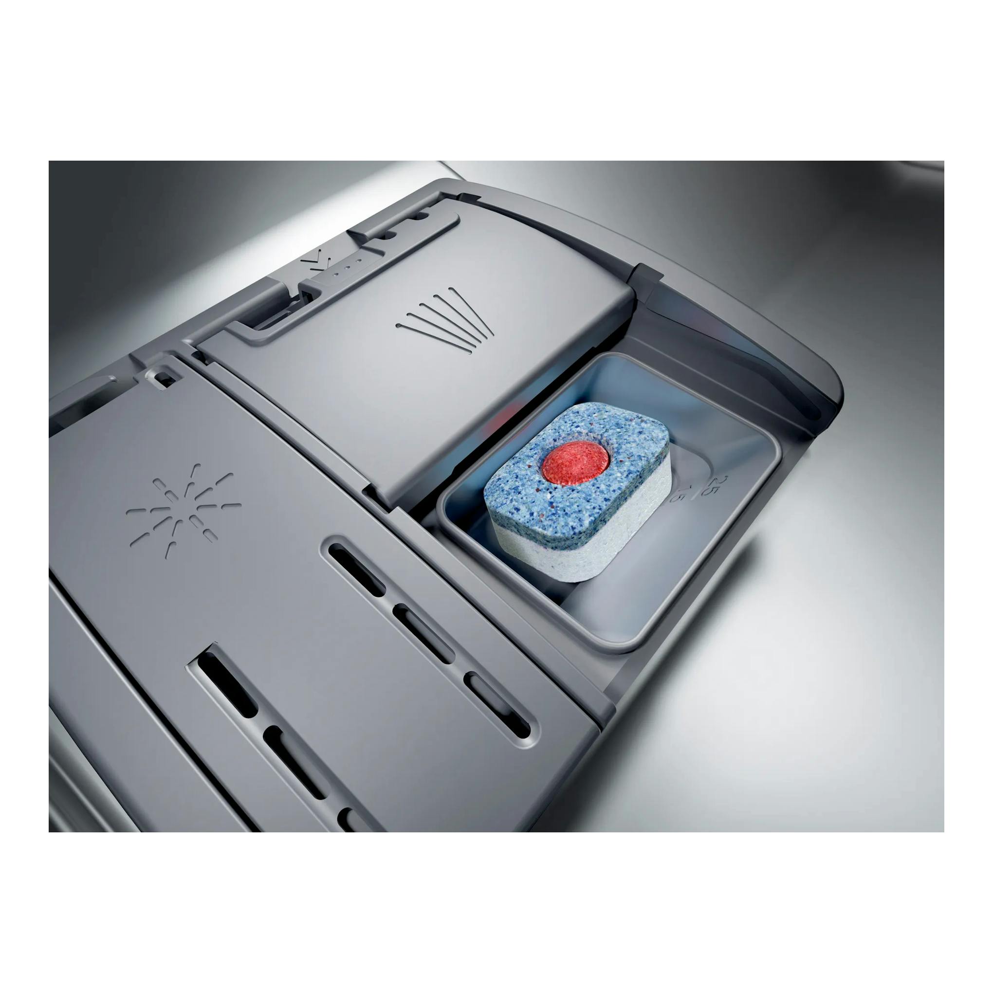 Primer plano del compartimento de detergente de un lavavajillas Bosch SBV6YCX02E, en gris, con pastilla dentro.