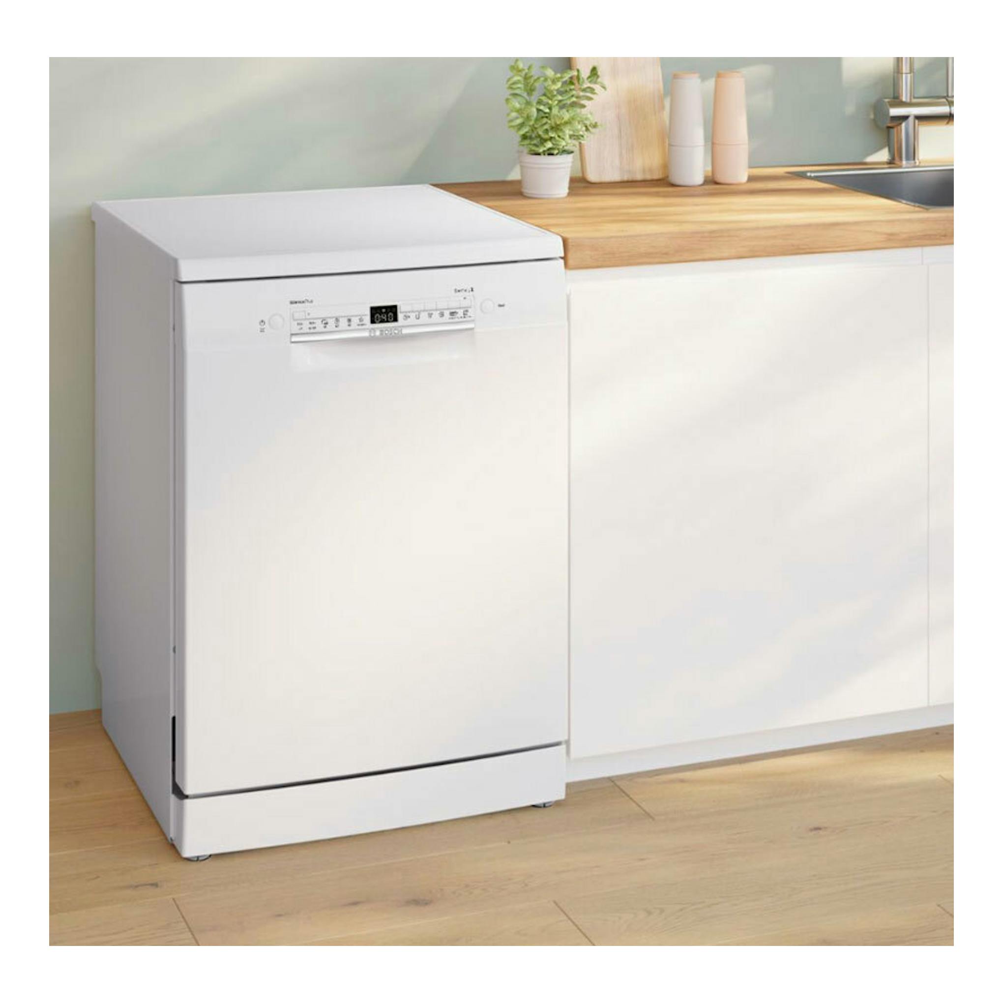 Lavavajillas Bosch SMS2HMW04E blanco, vista frontal, junto a una encimera de madera en una cocina.