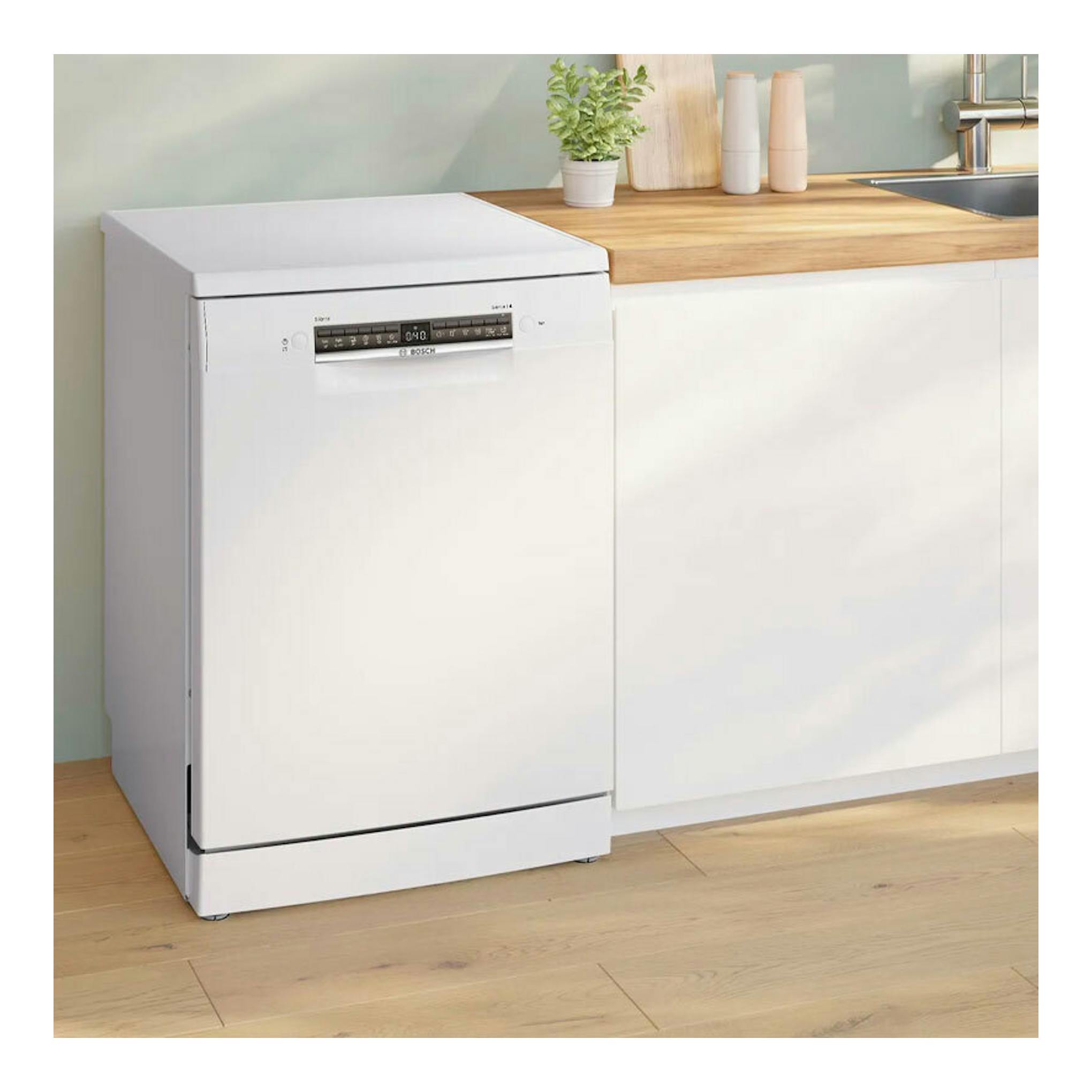 Lavavajillas Bosch SMS4HKW07E blanco, vista frontal en cocina junto a encimera de madera.