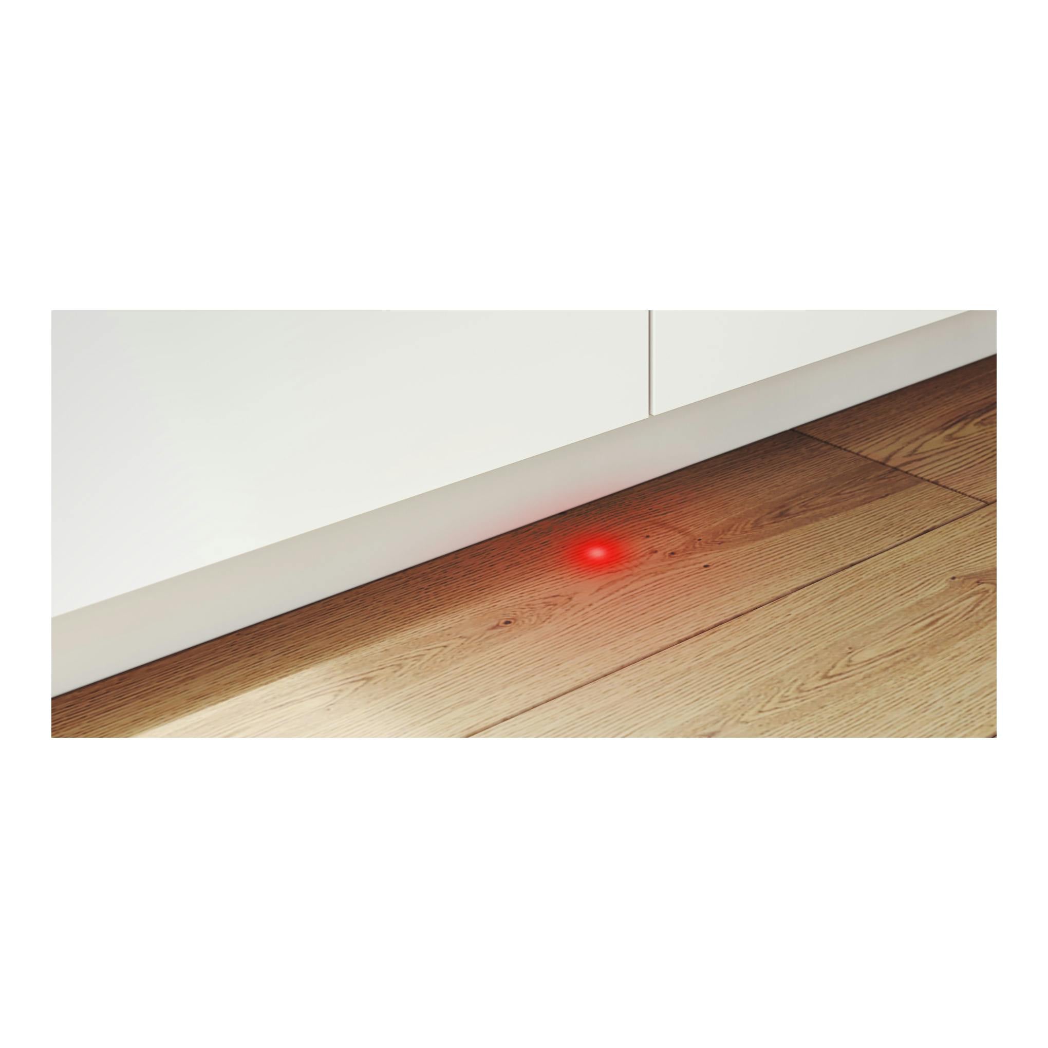Lavavajillas Bosch SMV4ECX21E integrable, vista frontal baja de panel blanco sobre suelo de madera, luz roja en el suelo.