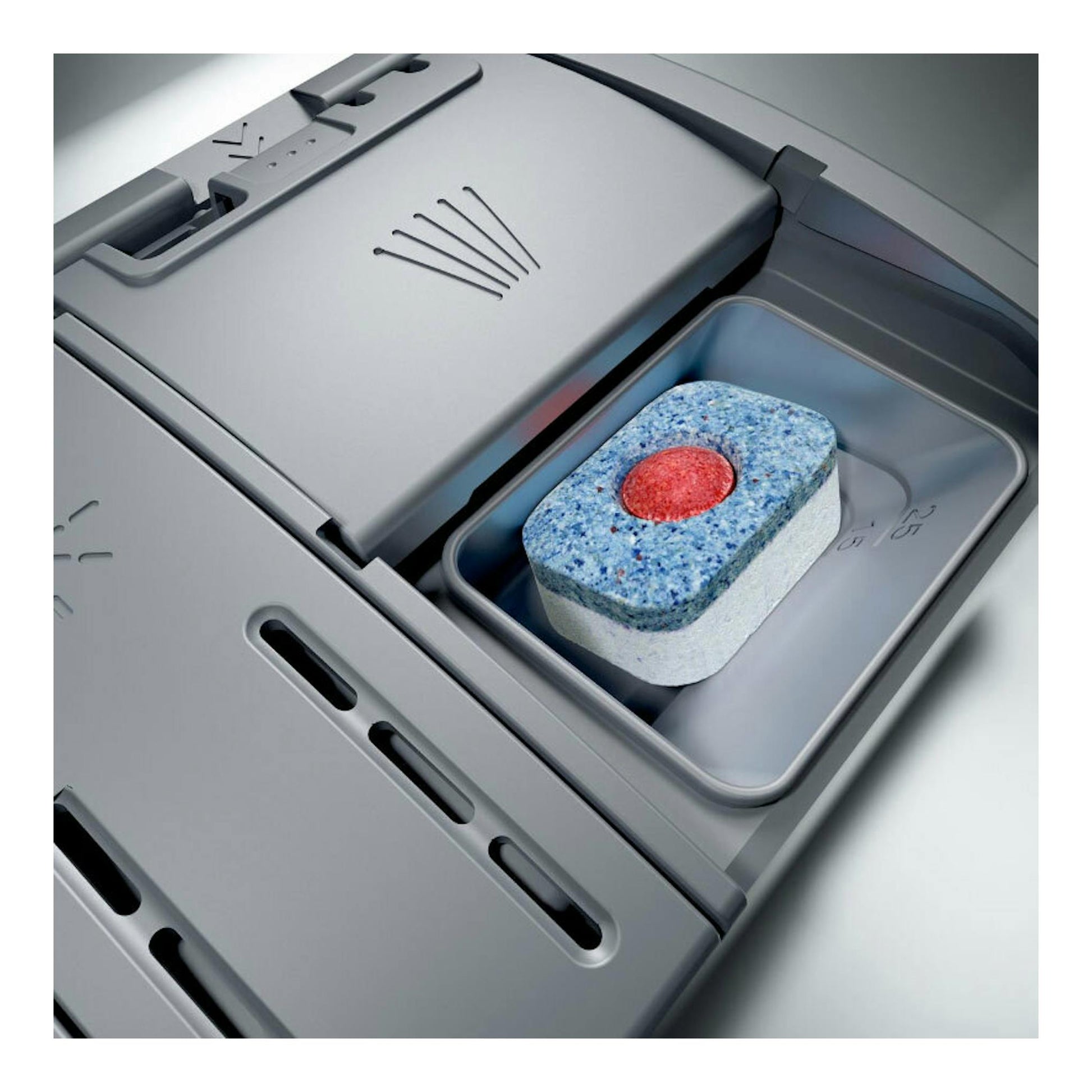 Primer plano del compartimento de un lavavajillas Bosch SPS2HKW58E en gris, con una pastilla detergente.