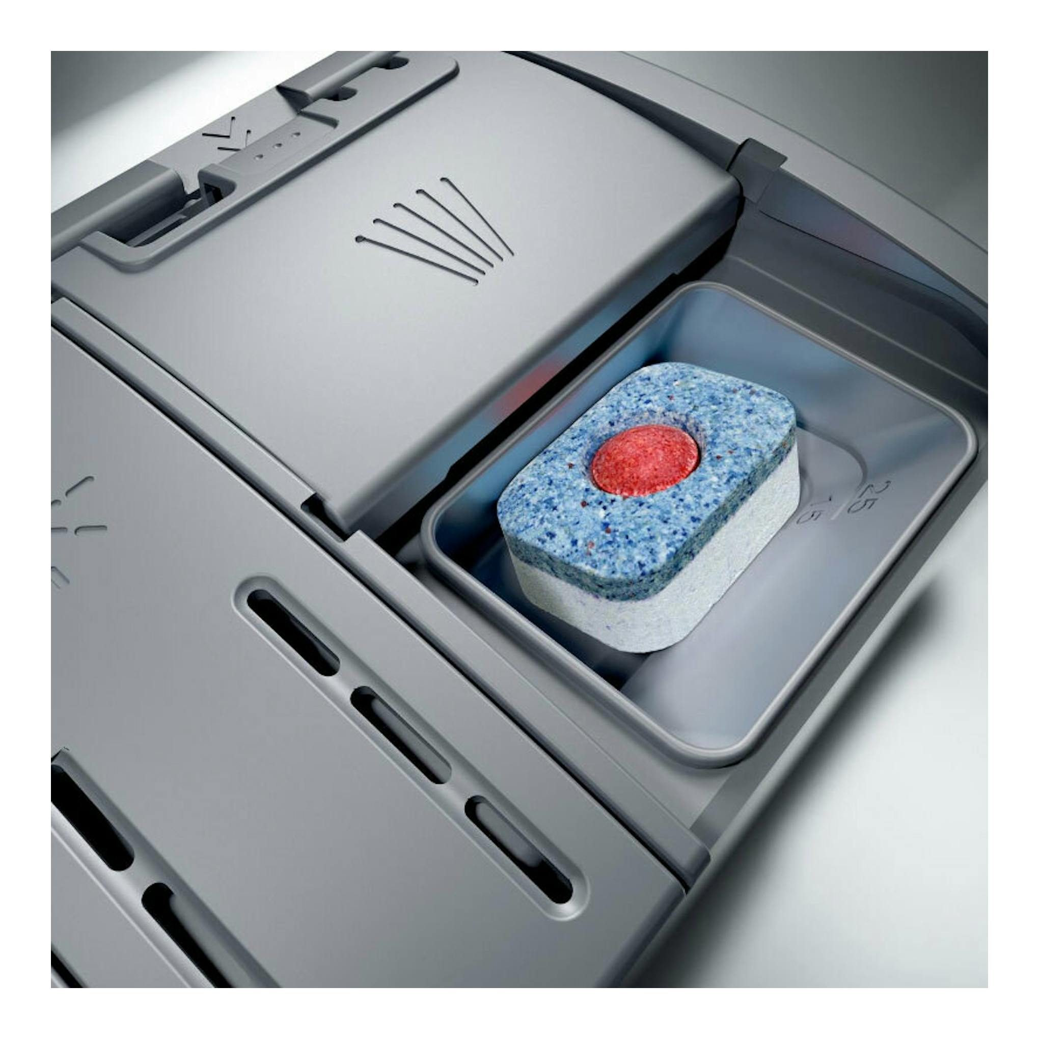 Primer plano del compartimento de un lavavajillas Bosch SPS2HKW58E en gris, con una pastilla detergente.