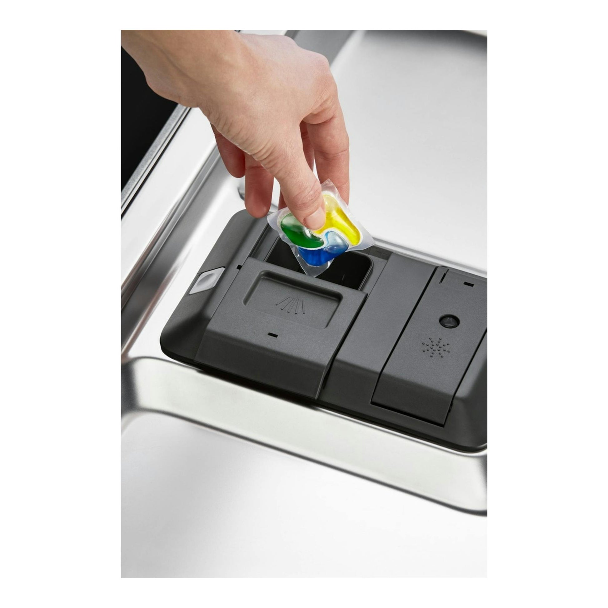 Electrolux ESS47400SX, primer plano del dispensador de un lavavajillas inox con una mano colocando una pastilla.