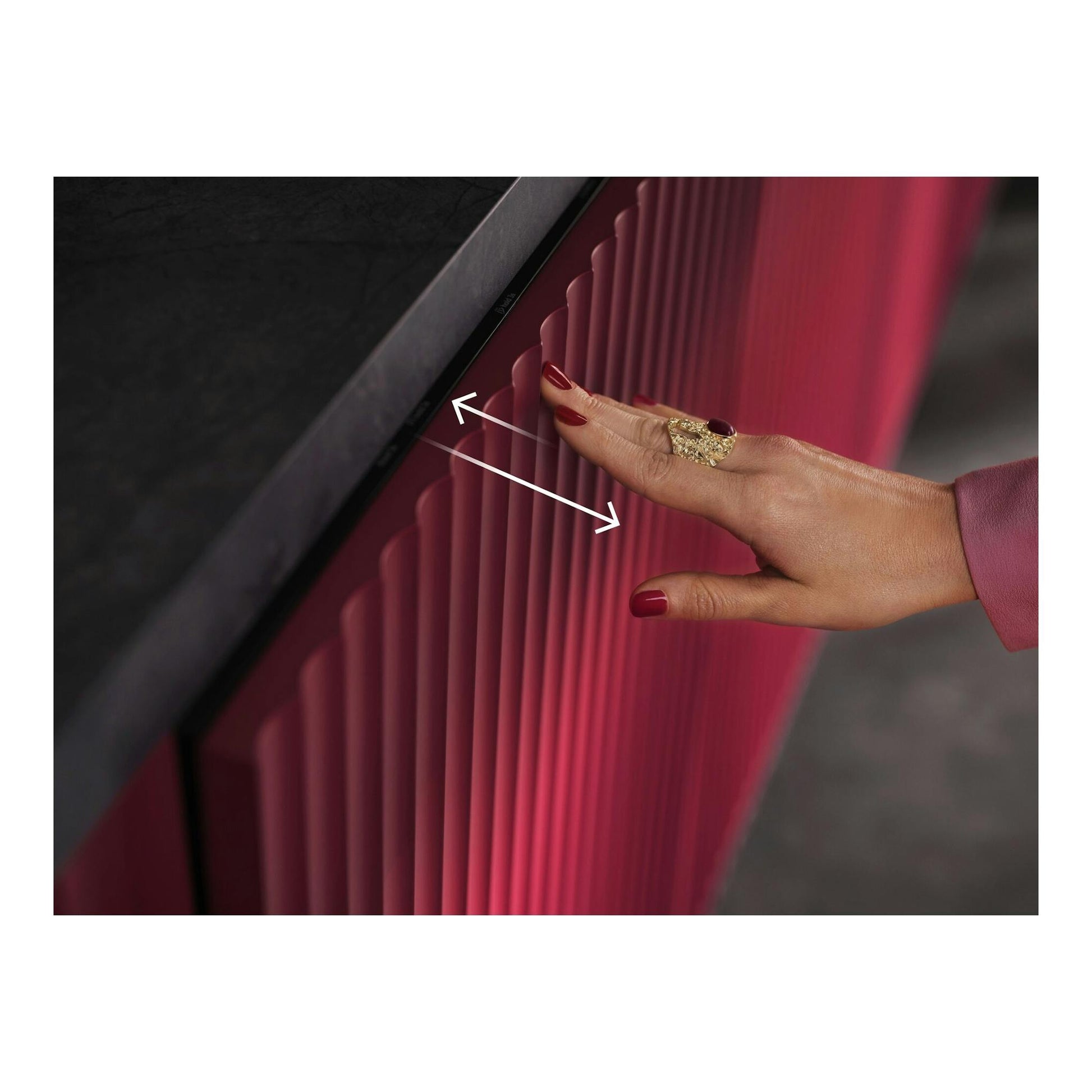 AEG GI8700A2PN, primer plano de un panel frontal rosa texturizado con una mano y flechas blancas.