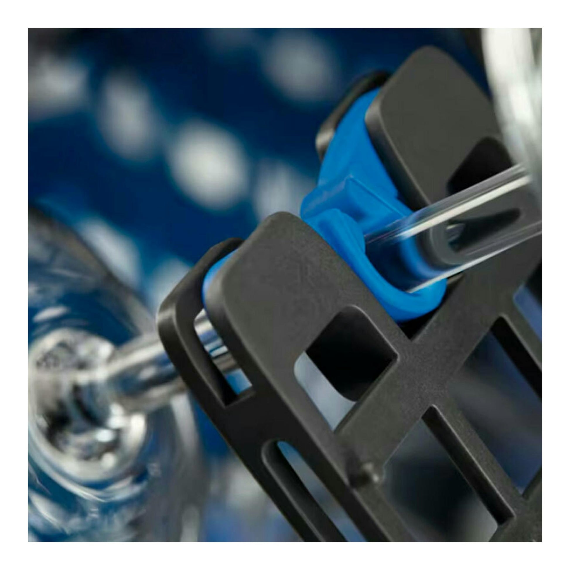 Primer plano del interior de un lavavajillas Electrolux EEG68500L, con piezas negras y azules y un tubo transparente.