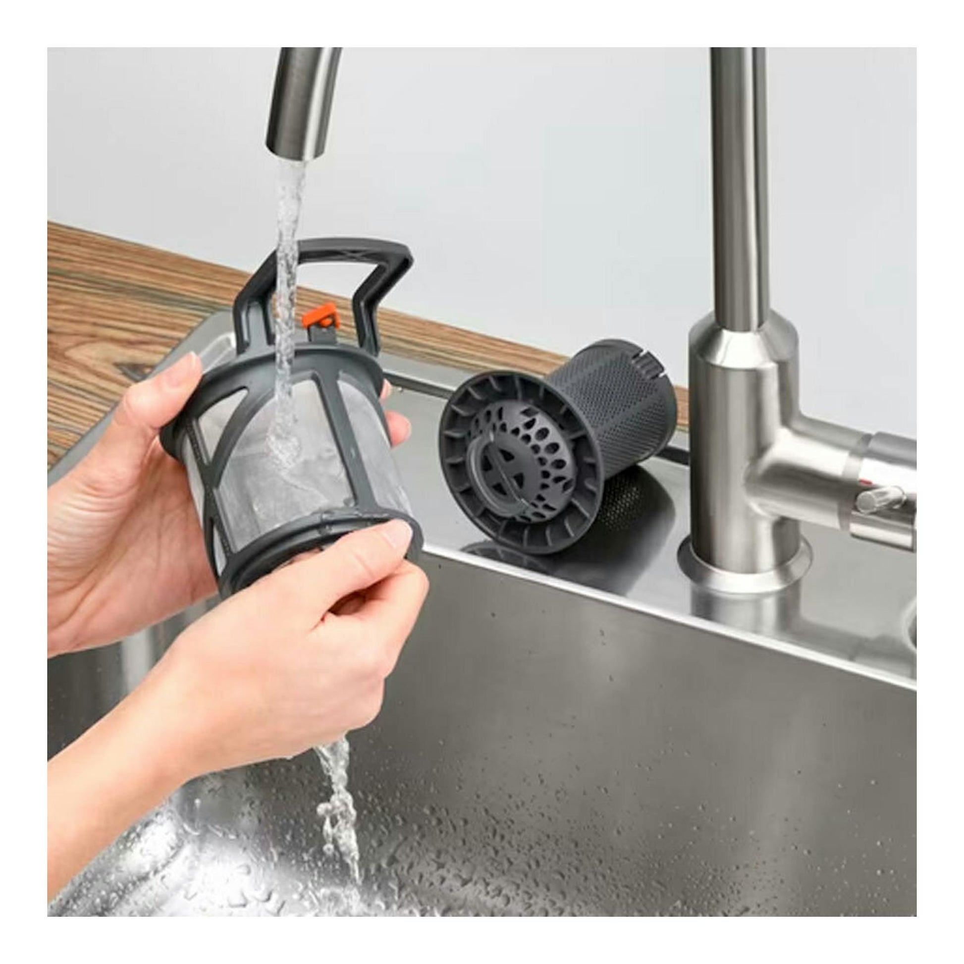 Manos lavando el filtro de un lavavajillas bajo un grifo de cocina; Electrolux LSV48400L