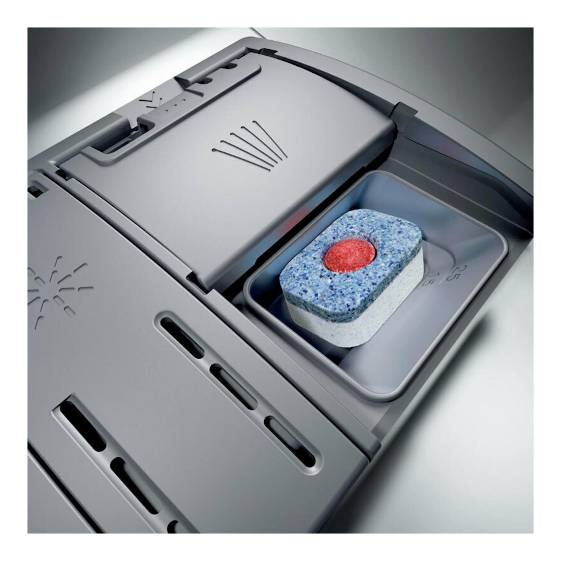 Lavavajillas integrable Siemens SX65ZX07CE, vista cenital del compartimento de detergente con pastilla, en gris.