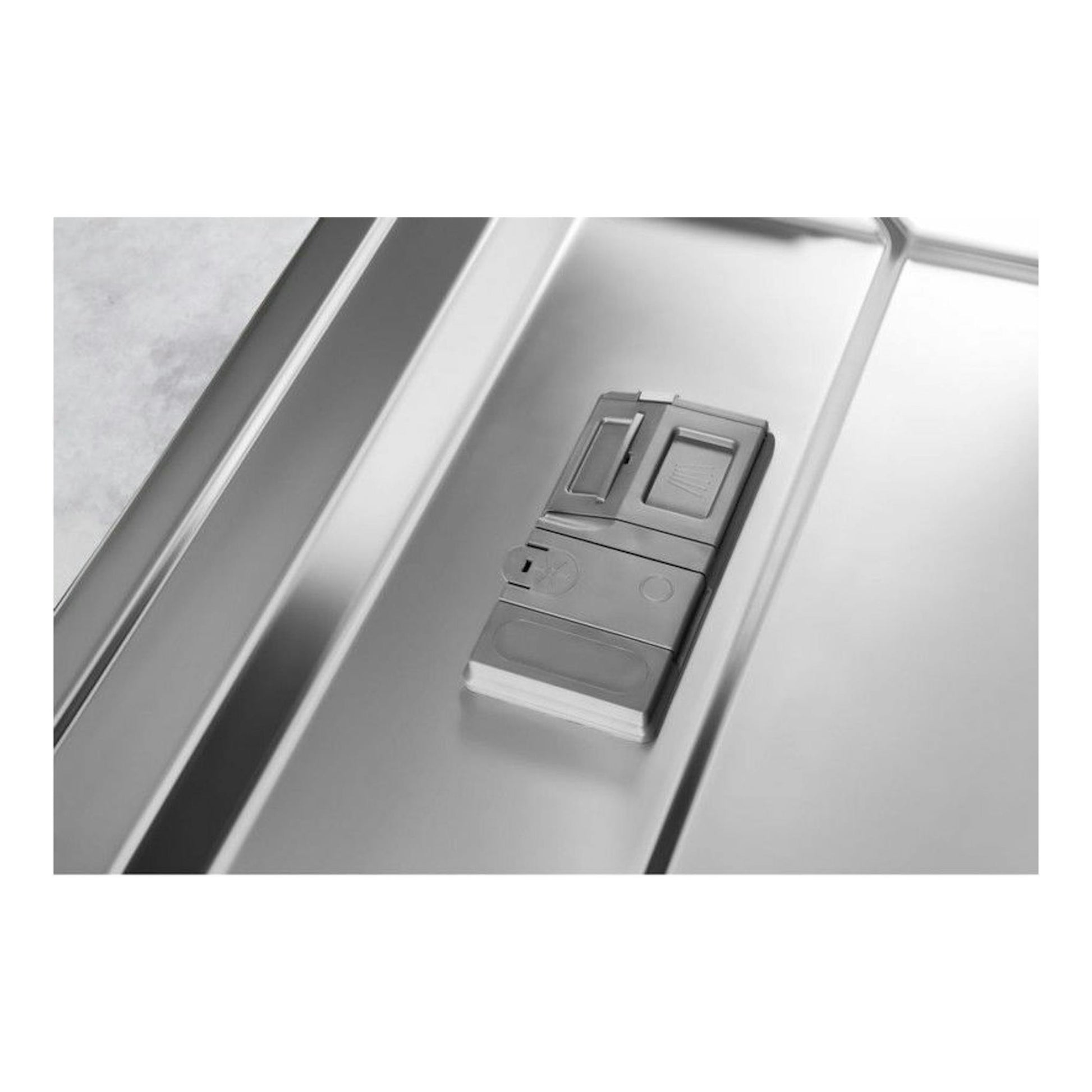 Primer plano del interior de un lavavajillas integrable Whirlpool WRIC3C26, en acero inoxidable, con dispensador.