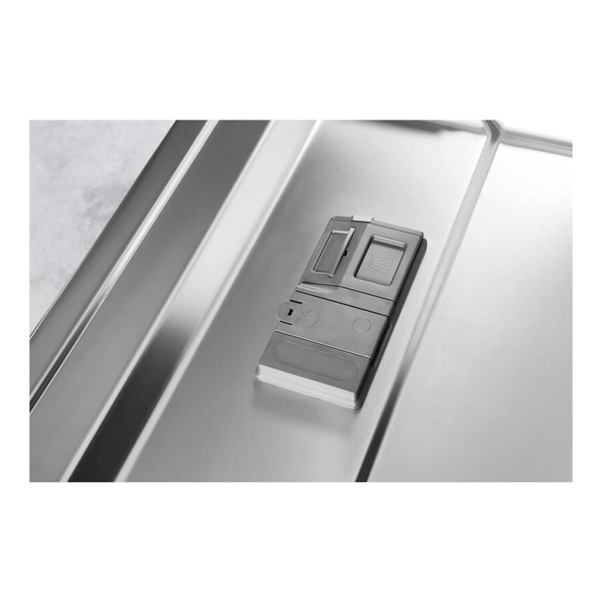 Interior de lavavajillas Whirlpool WFC3C26P, primer plano del dispensador gris sobre acero inoxidable.