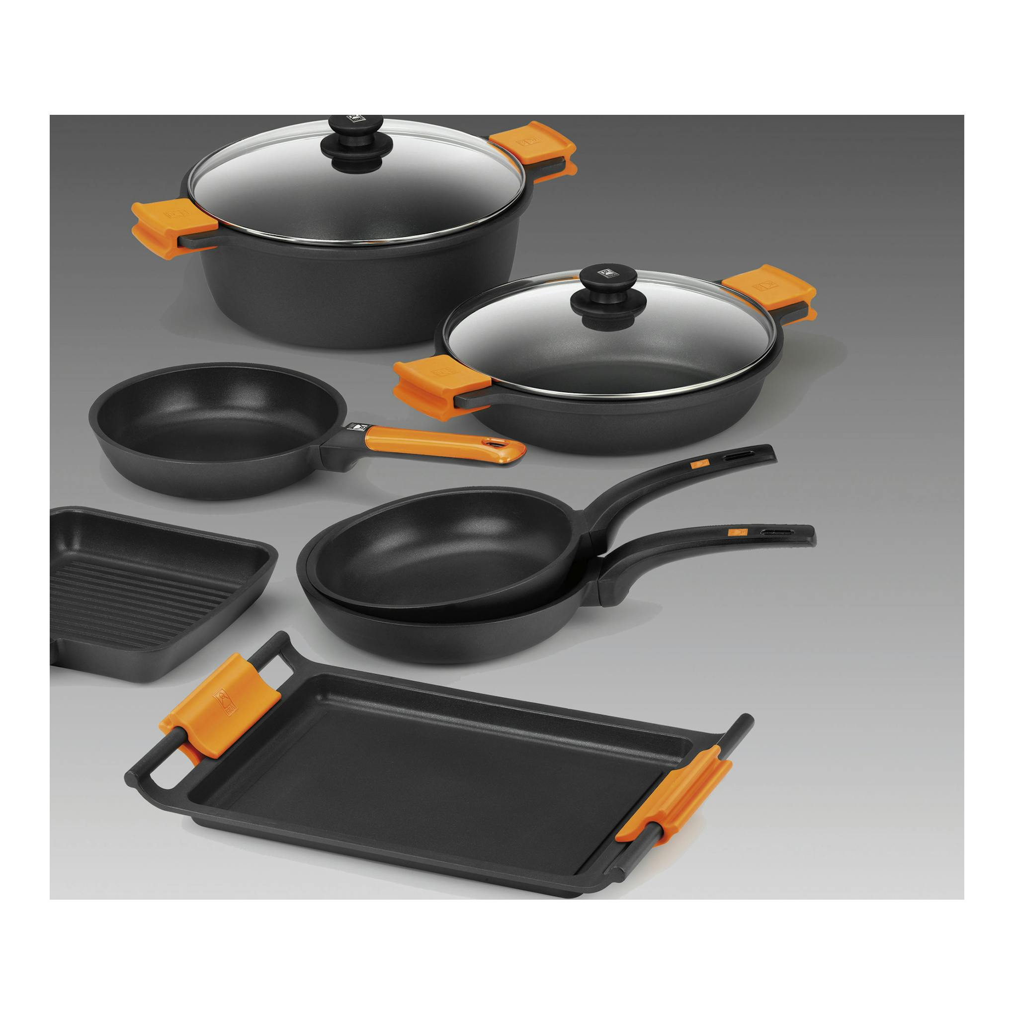 Batería de cocina BRA Efficient negra con tapas y asas naranjas, vista frontal sobre fondo gris.