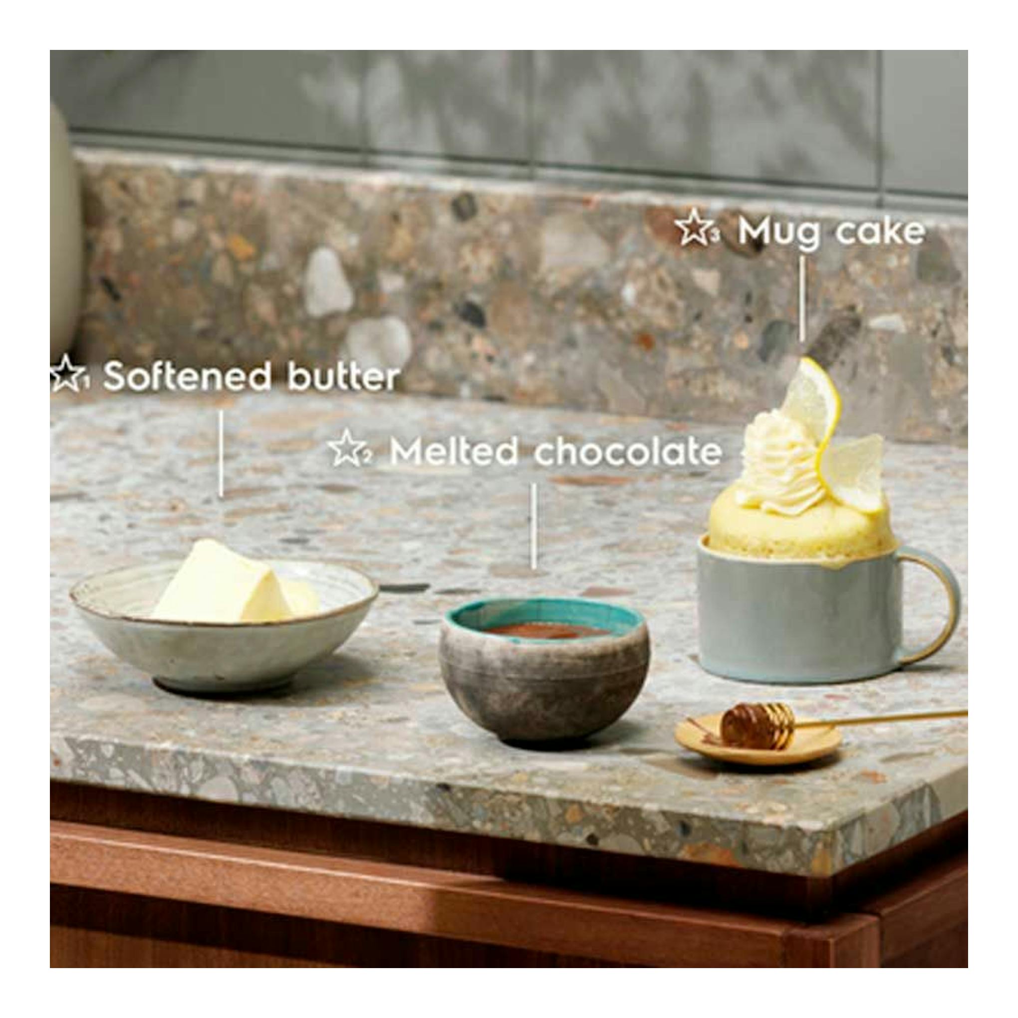Electrolux KMFD264TEX: taza con mug cake, mantequilla y chocolate sobre encimera de piedra.