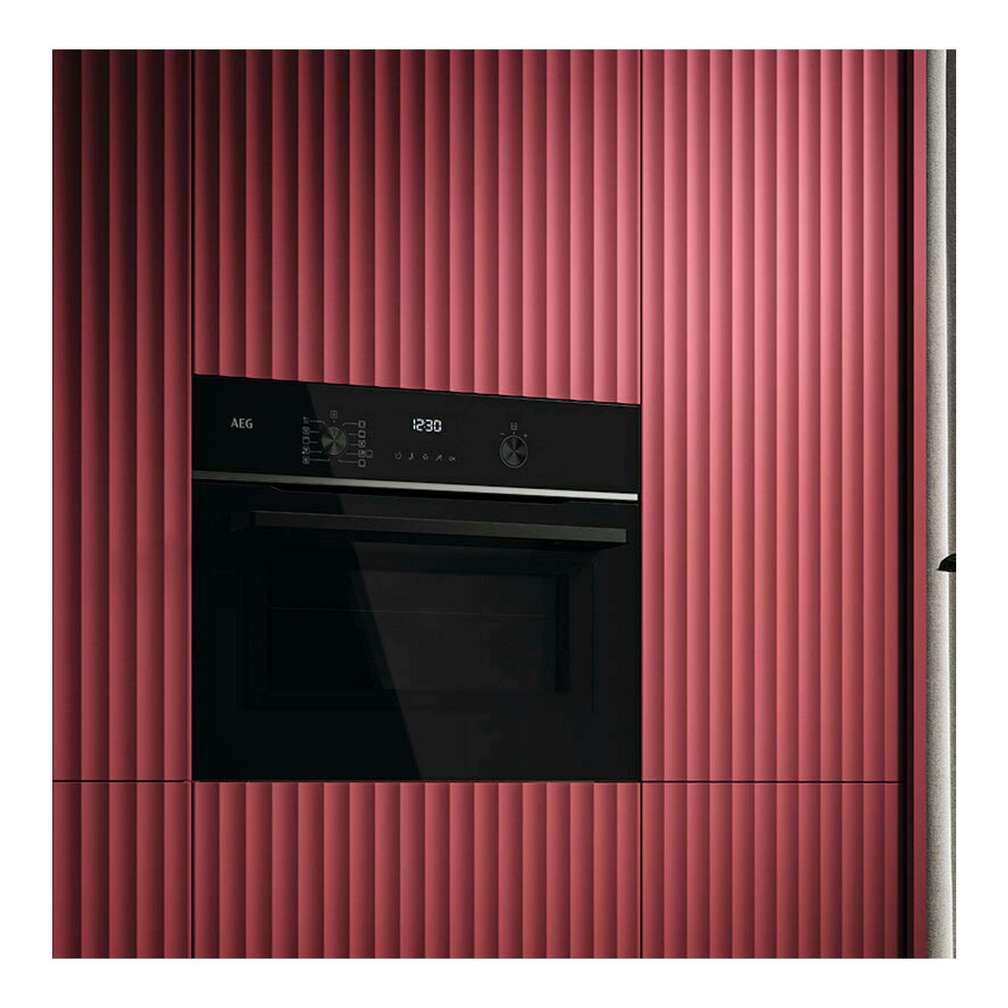 Microondas integrable AEG TM5NK401B negro, vista frontal, empotrado en mueble rosa.