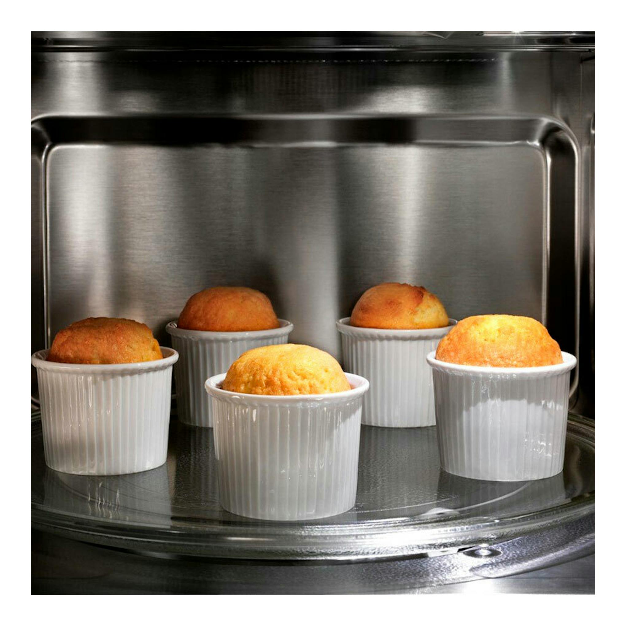 Microondas integrable Electrolux KMSE173MMX inox, vista interior con cinco magdalenas en moldes blancos.