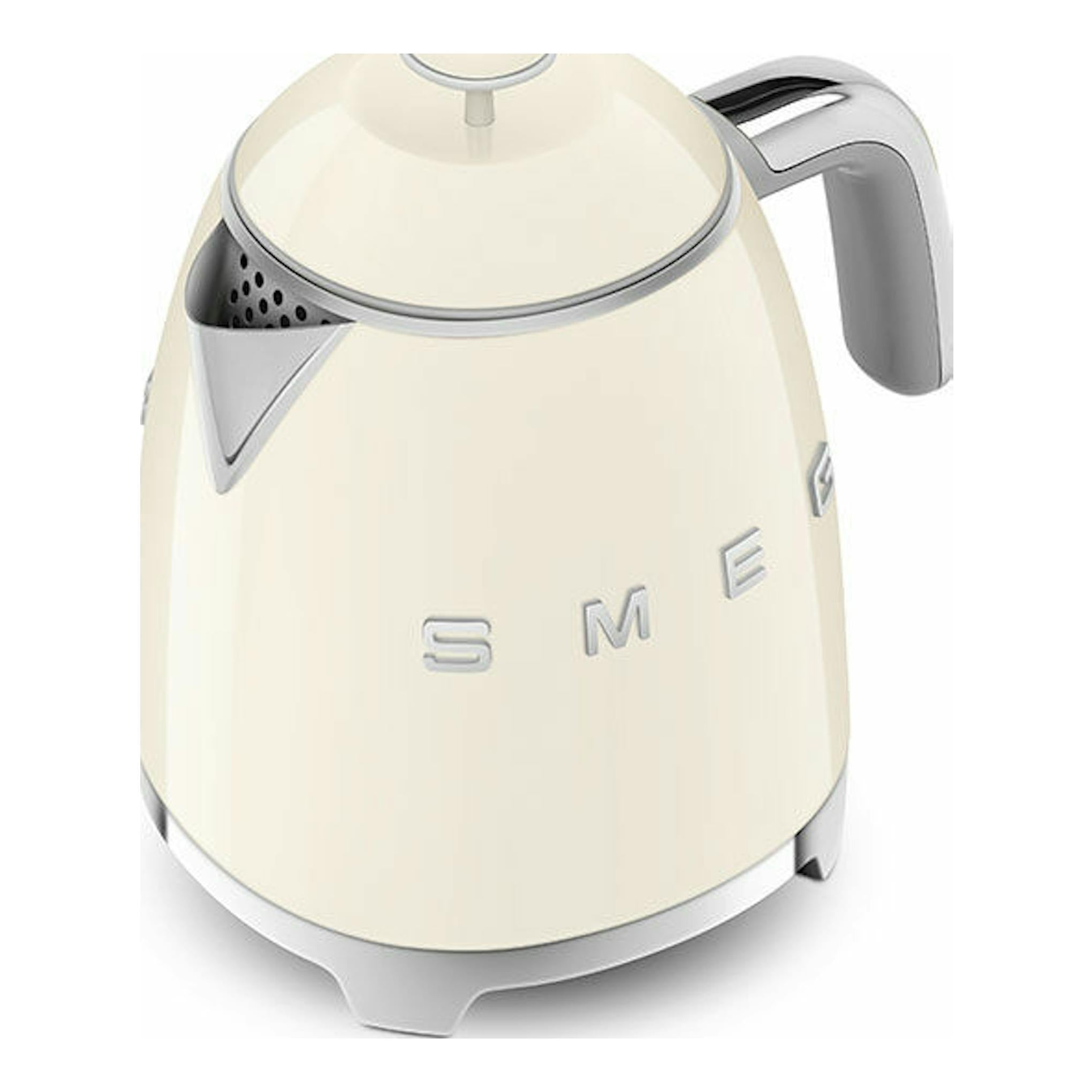 Mini hervidor Smeg KLF05CREU crema, vista frontal inclinada, con asa y detalles cromados.