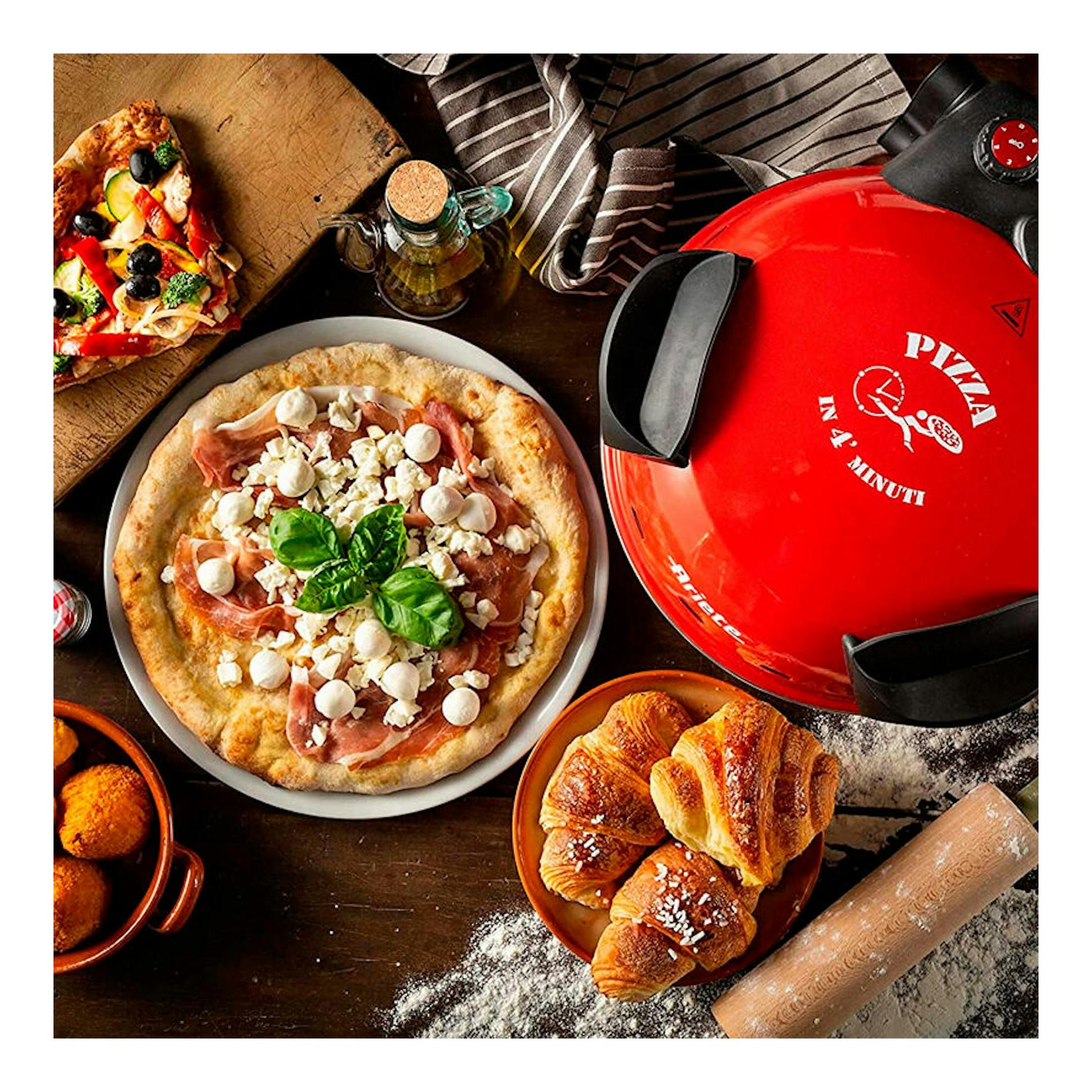 Mini horno Ariete 909 para pizza, rojo, vista superior, sobre mesa con pizzas y bollería.