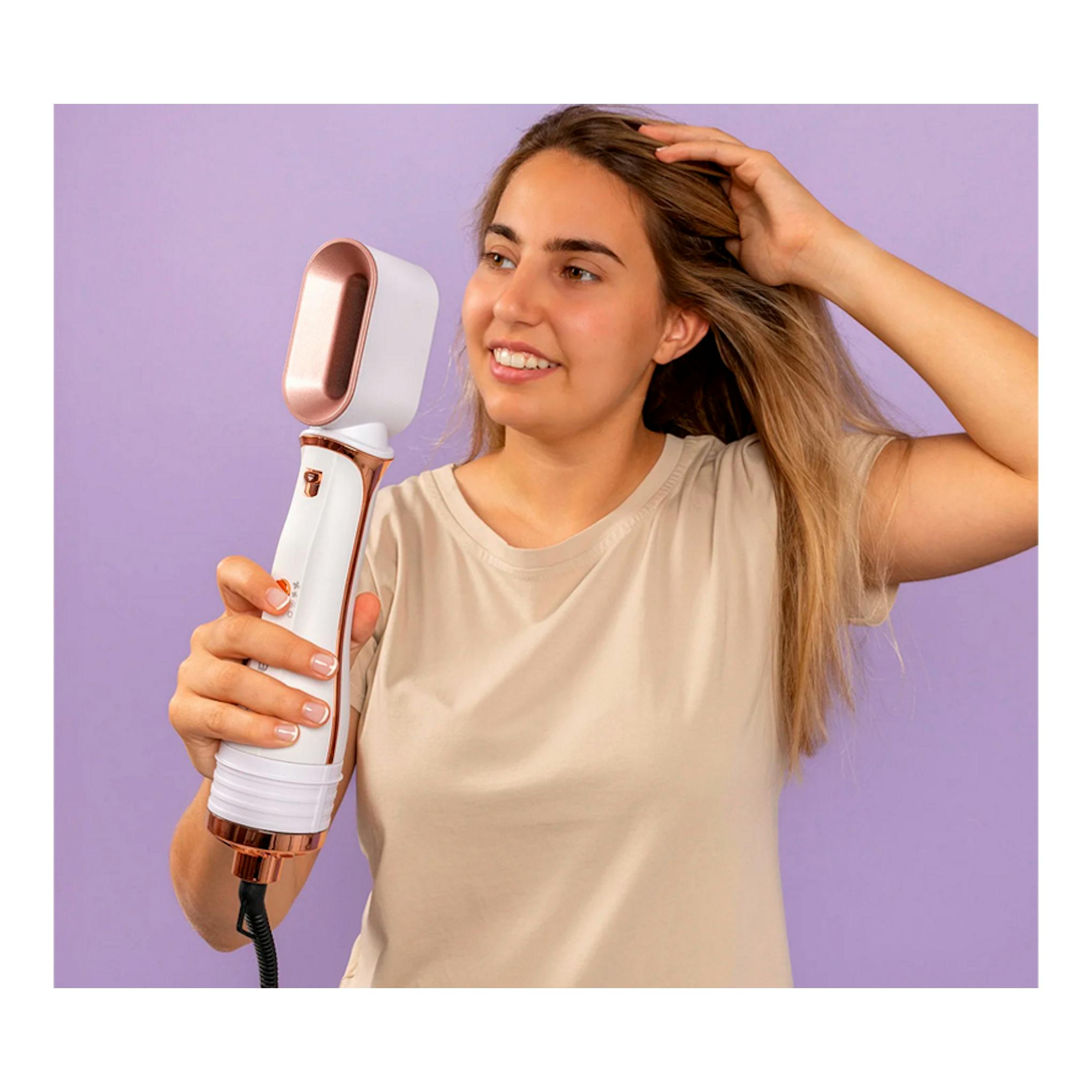 Moldeador Solac MD7405 Expert Ion Flow blanco y rosa, en manos de una mujer frente a fondo lila.