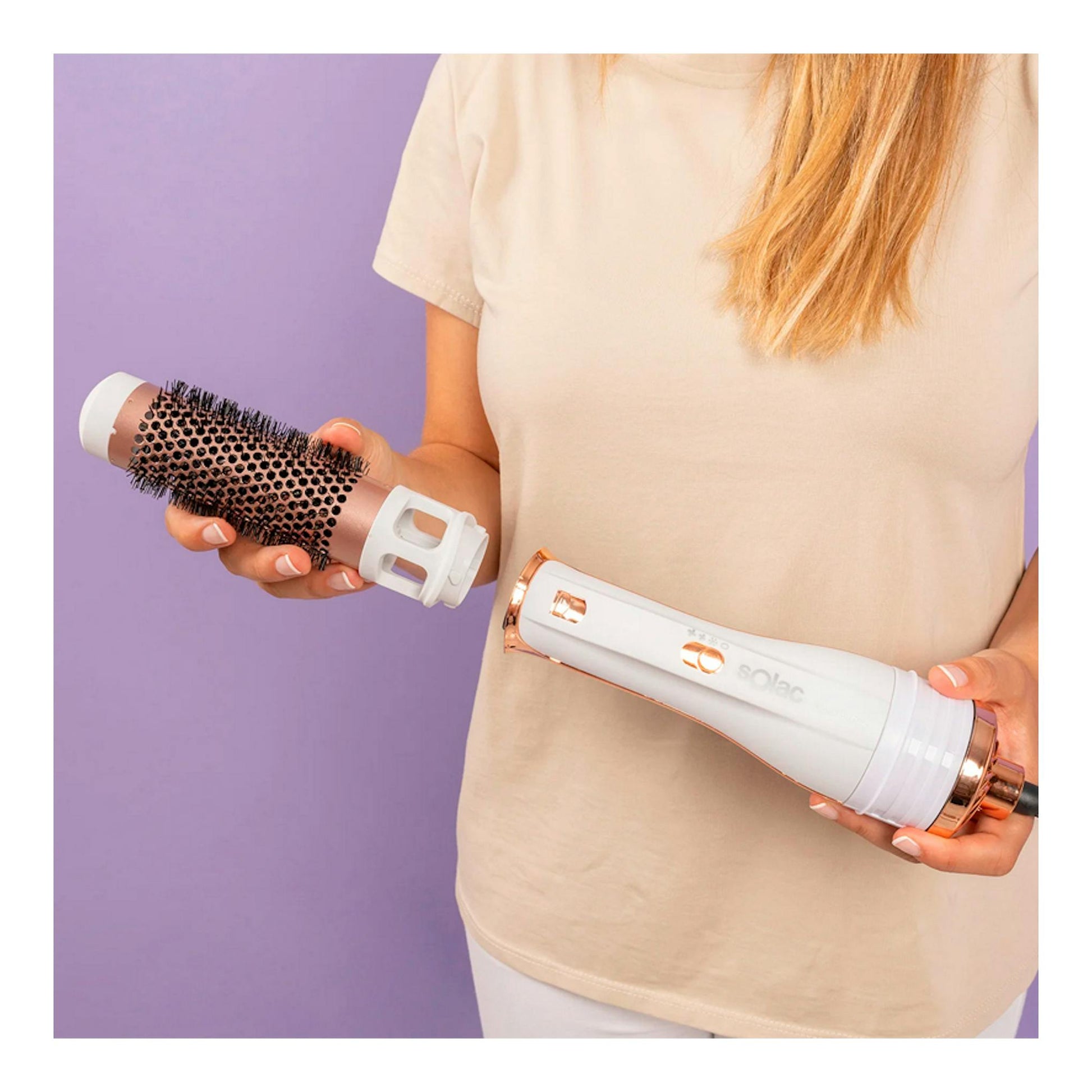 Moldeador Solac MD7405 Expert Ion Flow blanco y rosa, con accesorio cepillo, sostenido por una mujer.