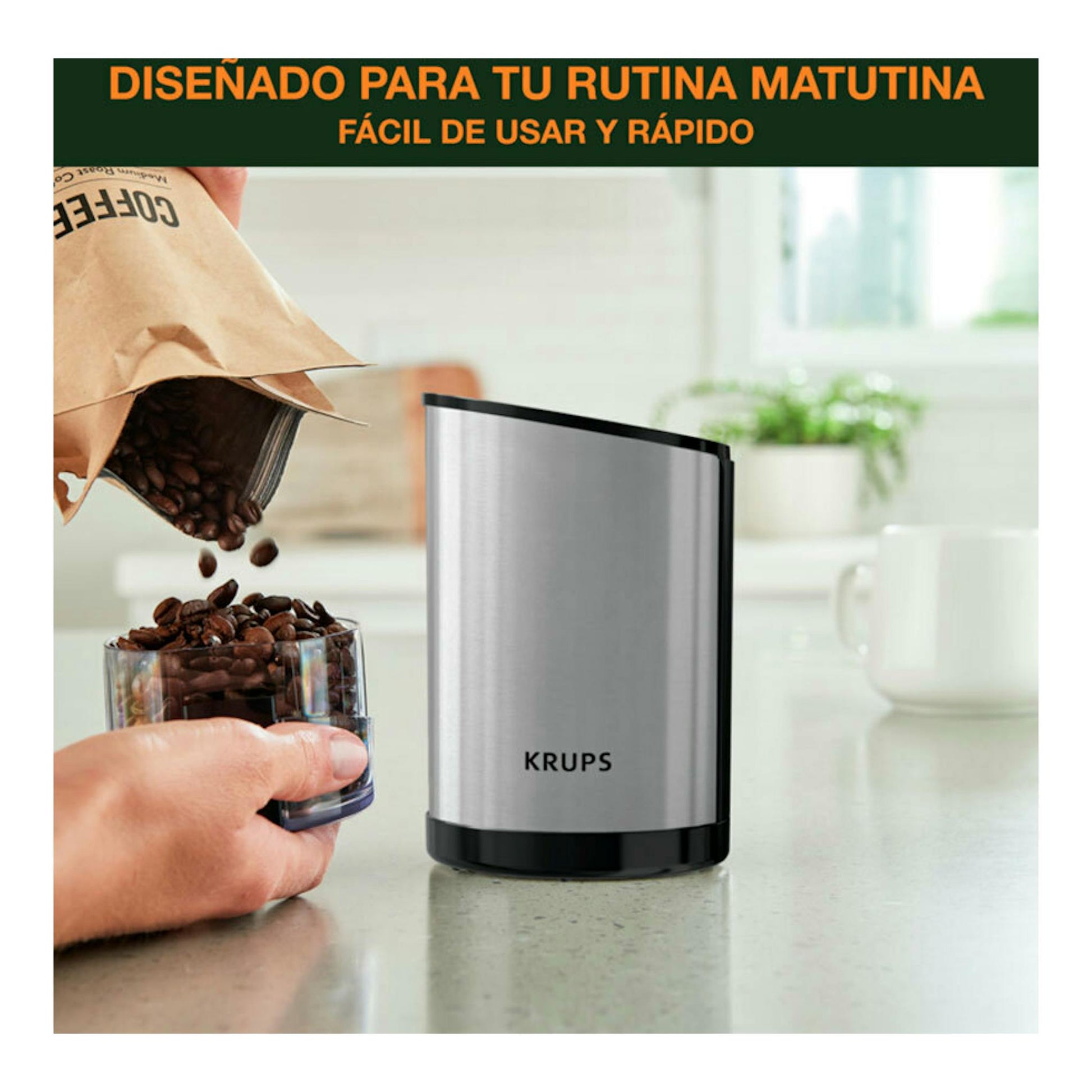 Molinillo de café Krups GX204D10 plateado y negro, vista frontal, sobre encimera junto a granos de café.