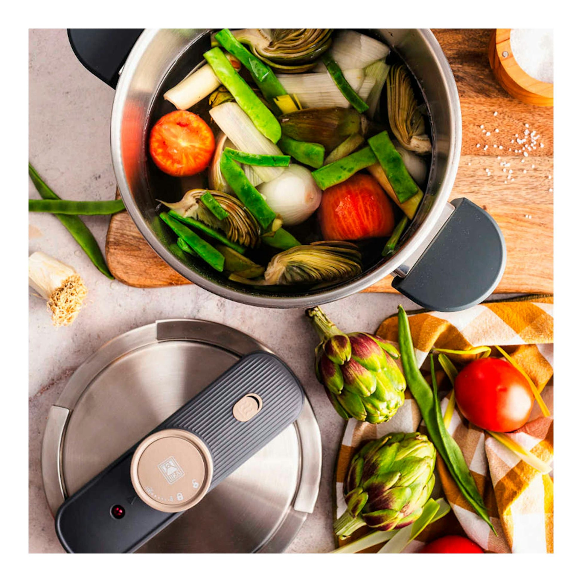 Vista cenital de olla Bra Set Duo Emotion de acero inoxidable, una abierta con verduras y otra con tapa.