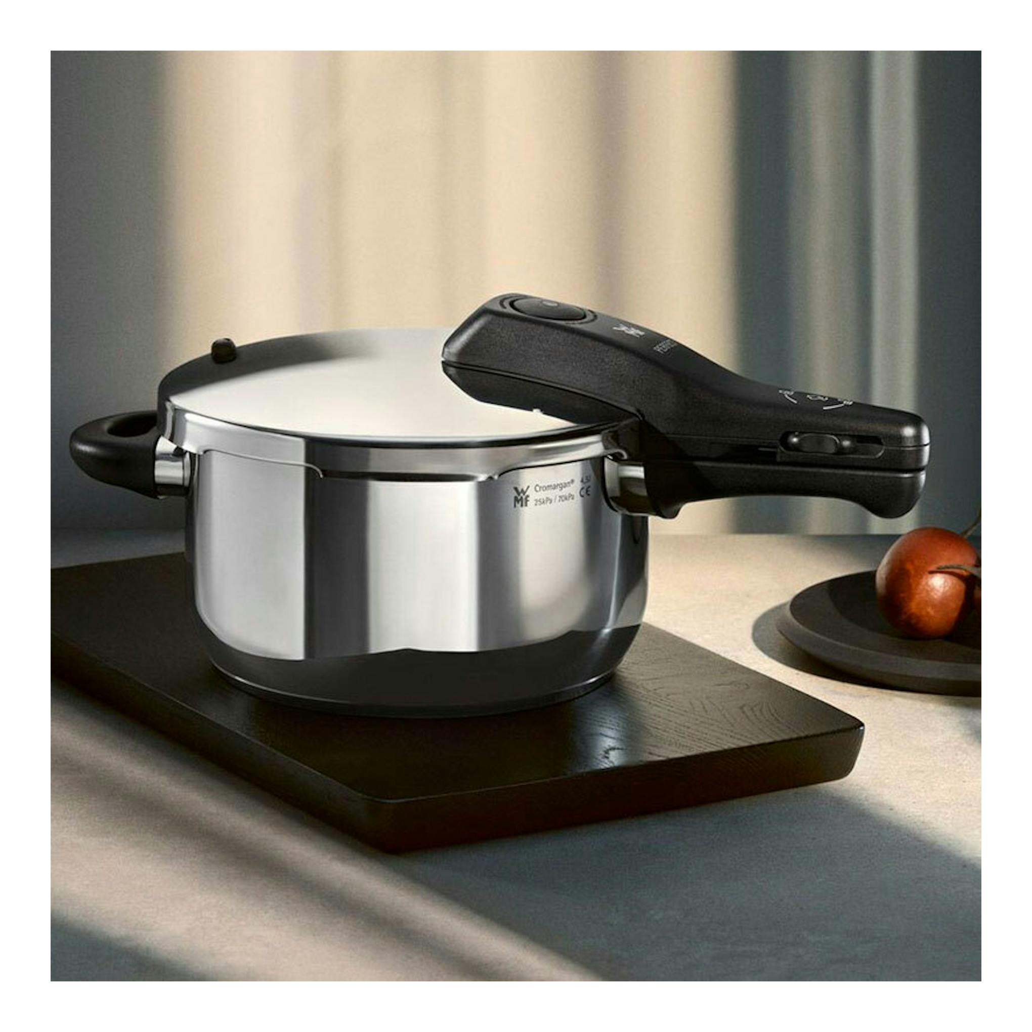 Olla rápida WMF Perfect 4,5 L de acero inoxidable, vista lateral, con tapa y asas negras.