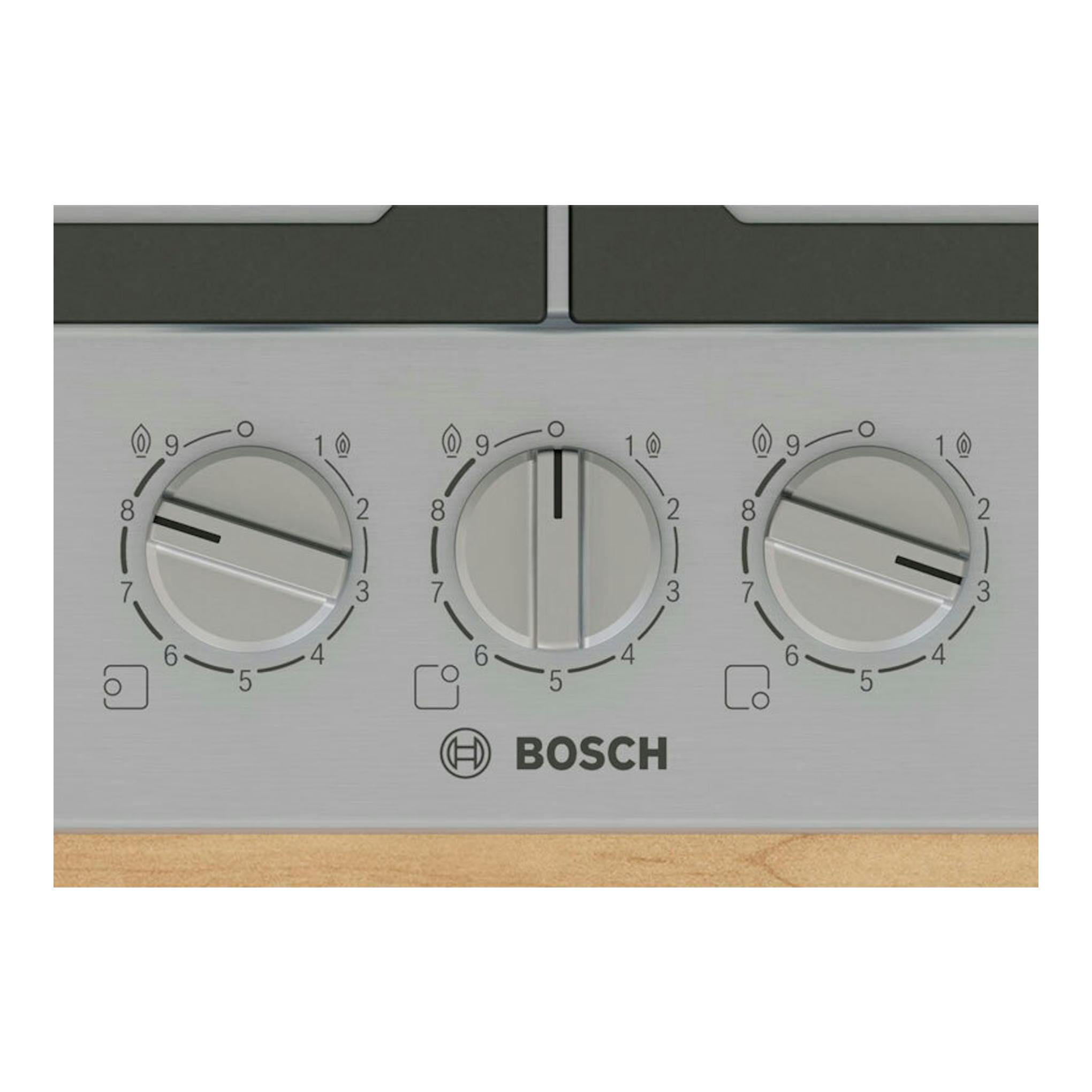 Placa de gas Bosch PCC6A5I90 de acero inoxidable, vista frontal con tres mandos circulares.